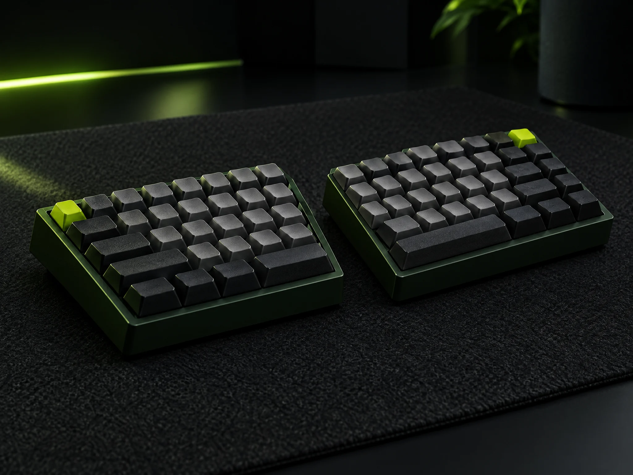 A split graphite keyboard in two green-framed halves on a dark desk mat, one lime key on each half