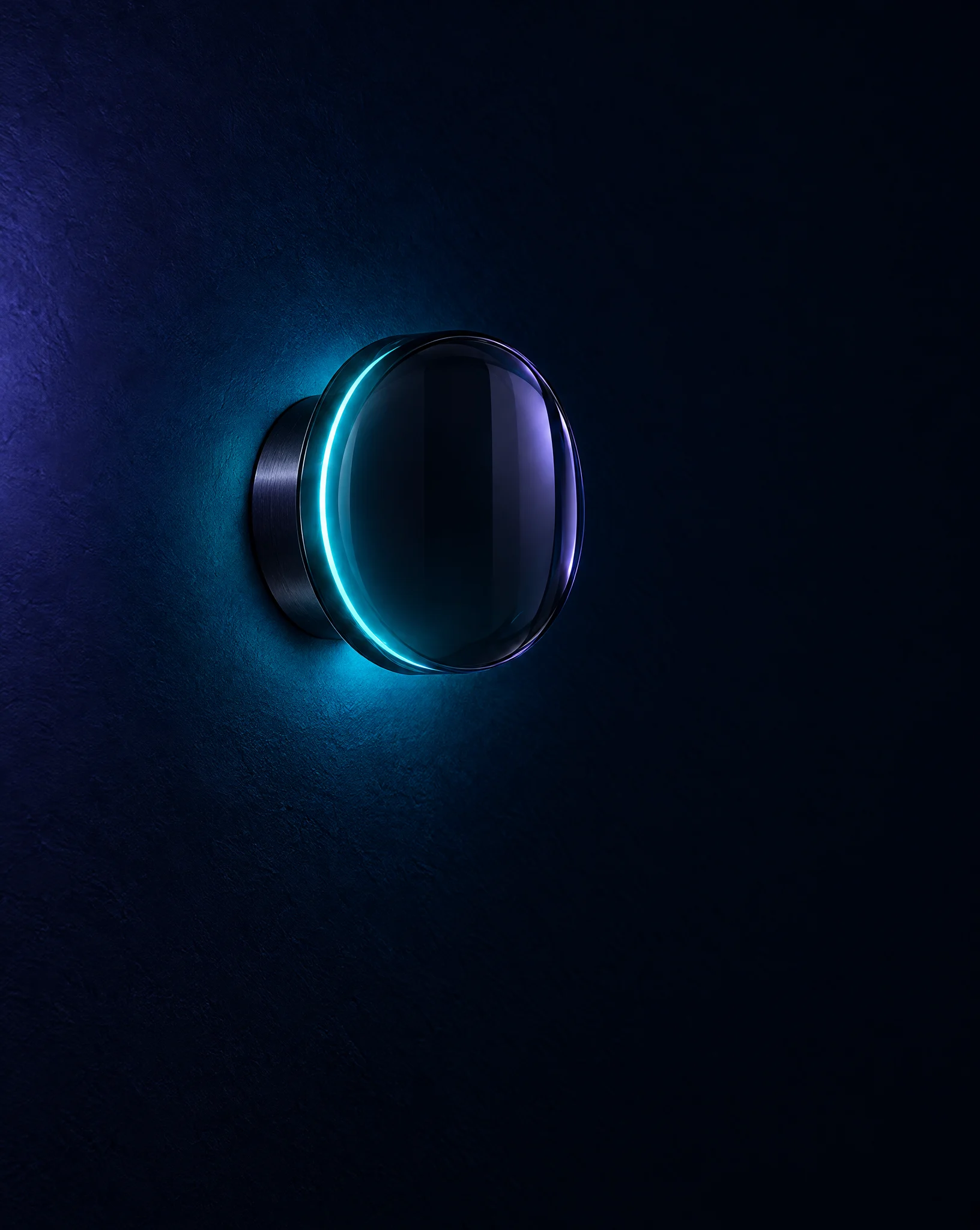 A round glass wall light with a thin cyan ring glowing at its edge on a dark wall