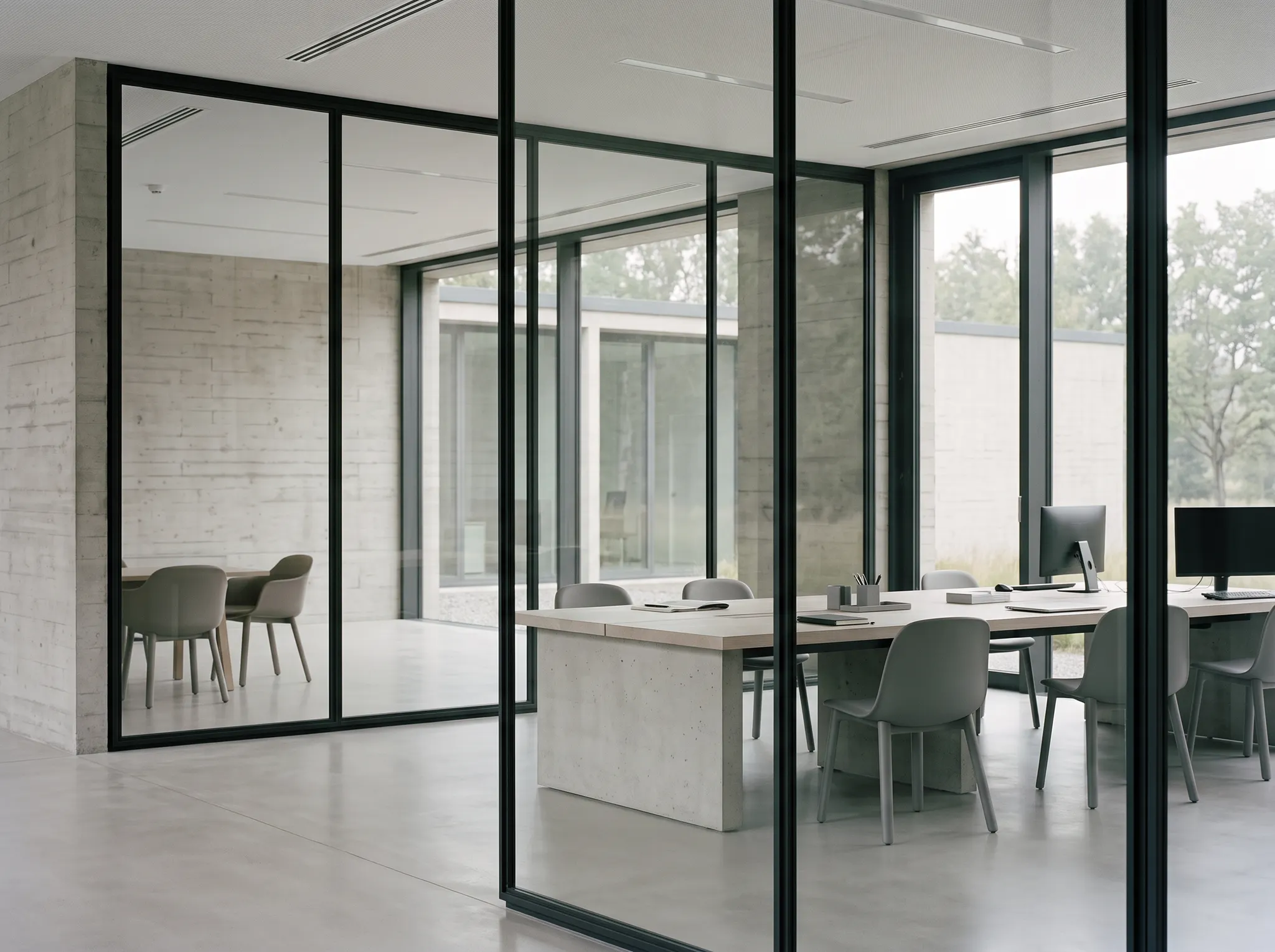 Daylit collaborative office with glass partitions and shared desks