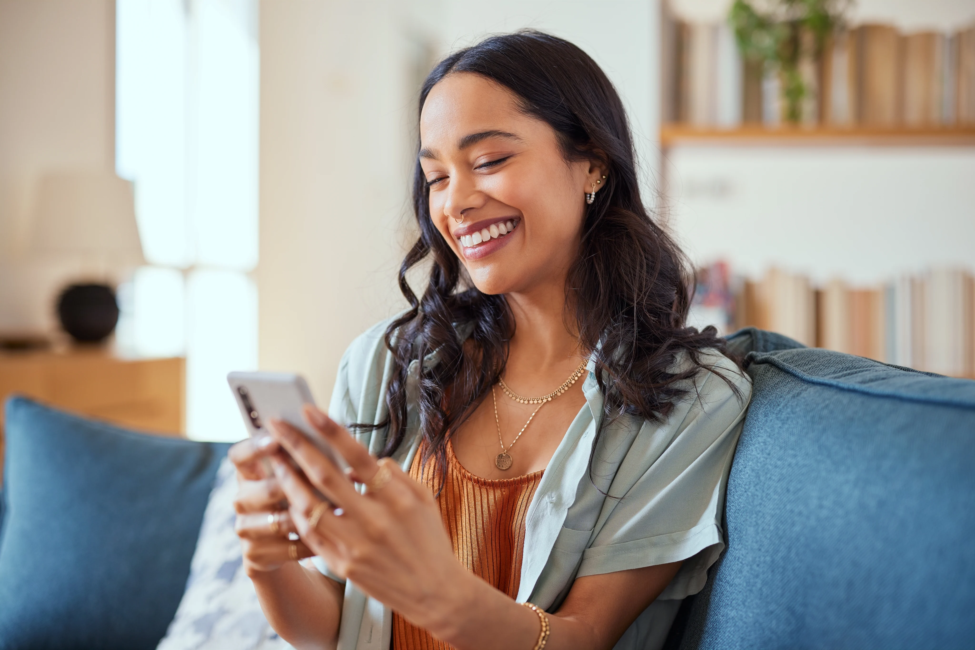 A woman relaxing on a sofa while looking at her phone