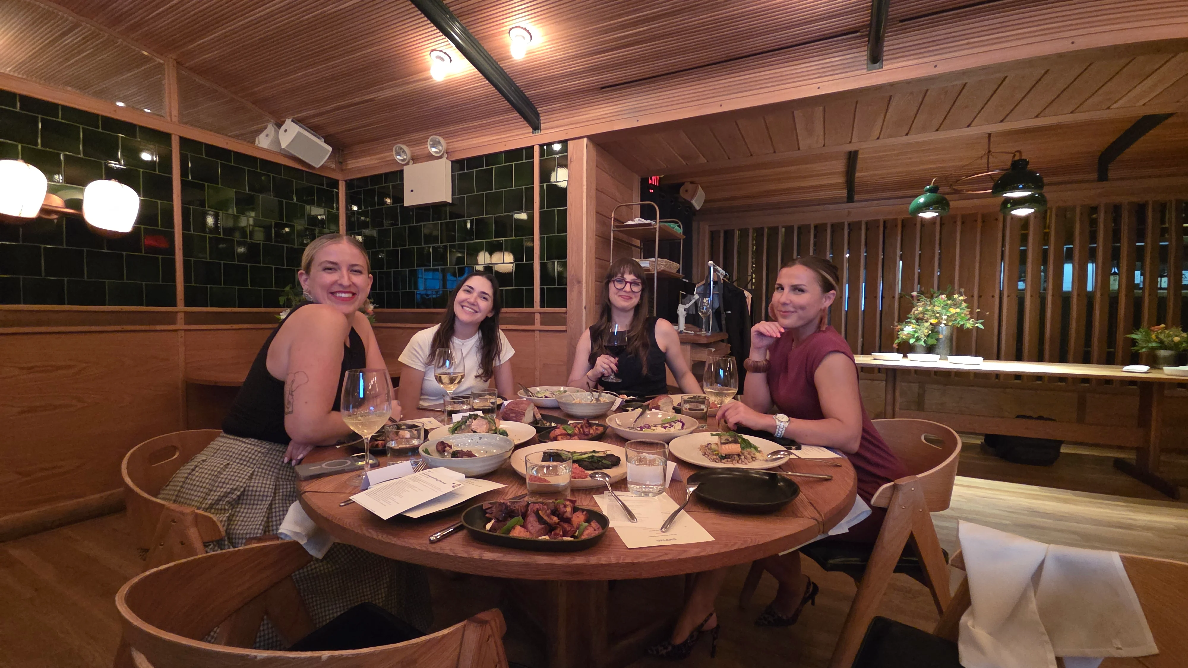 Four event marketers sharing dinner around a table at Upland