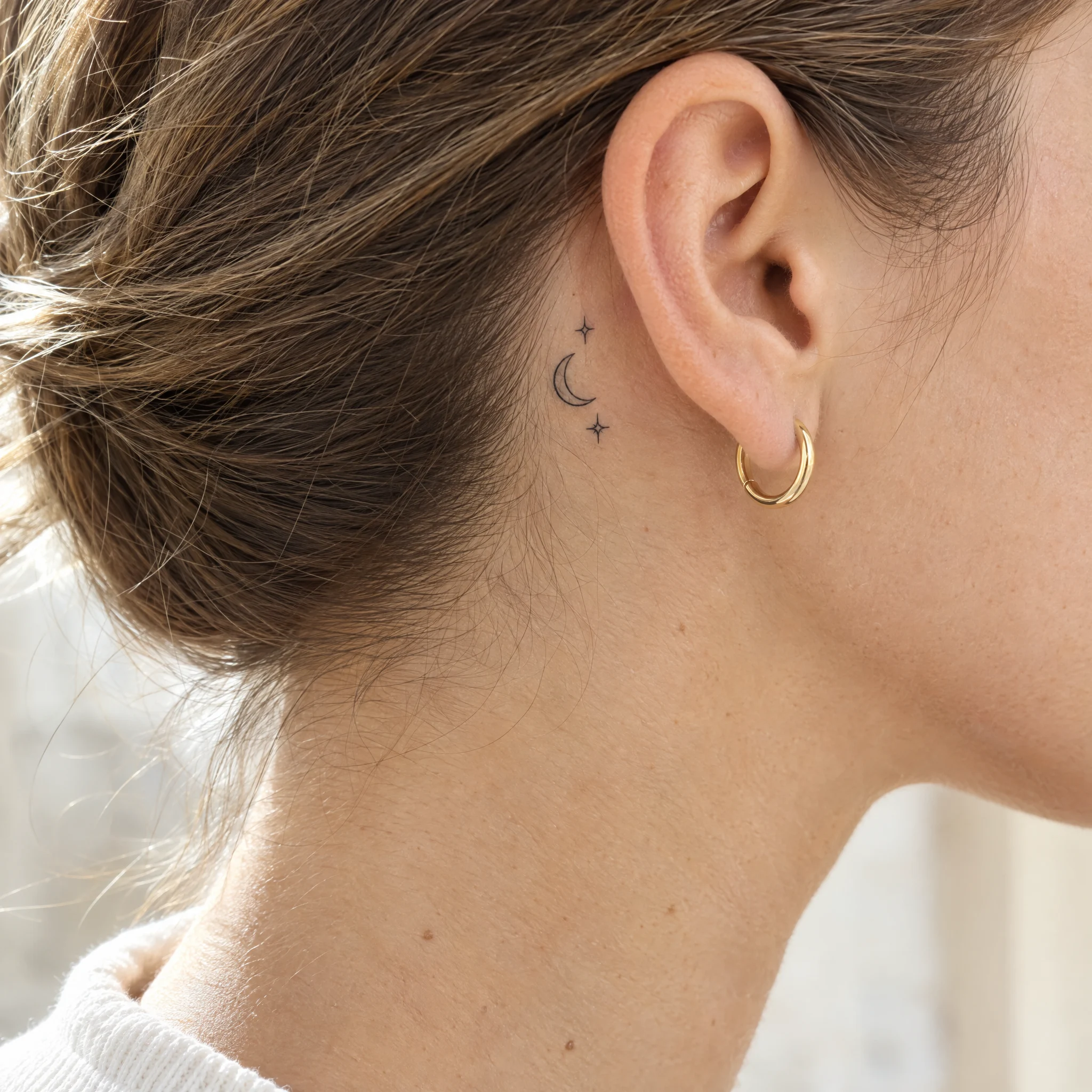 Tiny crescent moon and stars temporary tattoo behind the ear