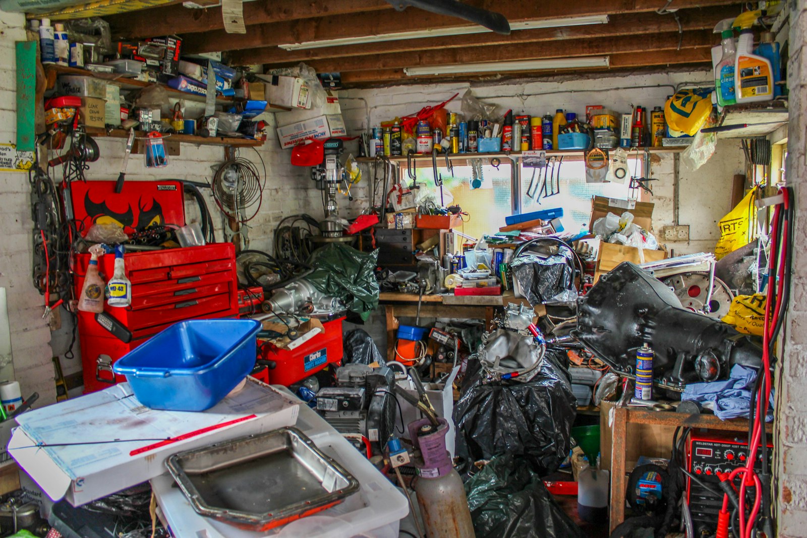 A cramped non-WareSpace garage crowded with tools, equipment, parts, and storage bins