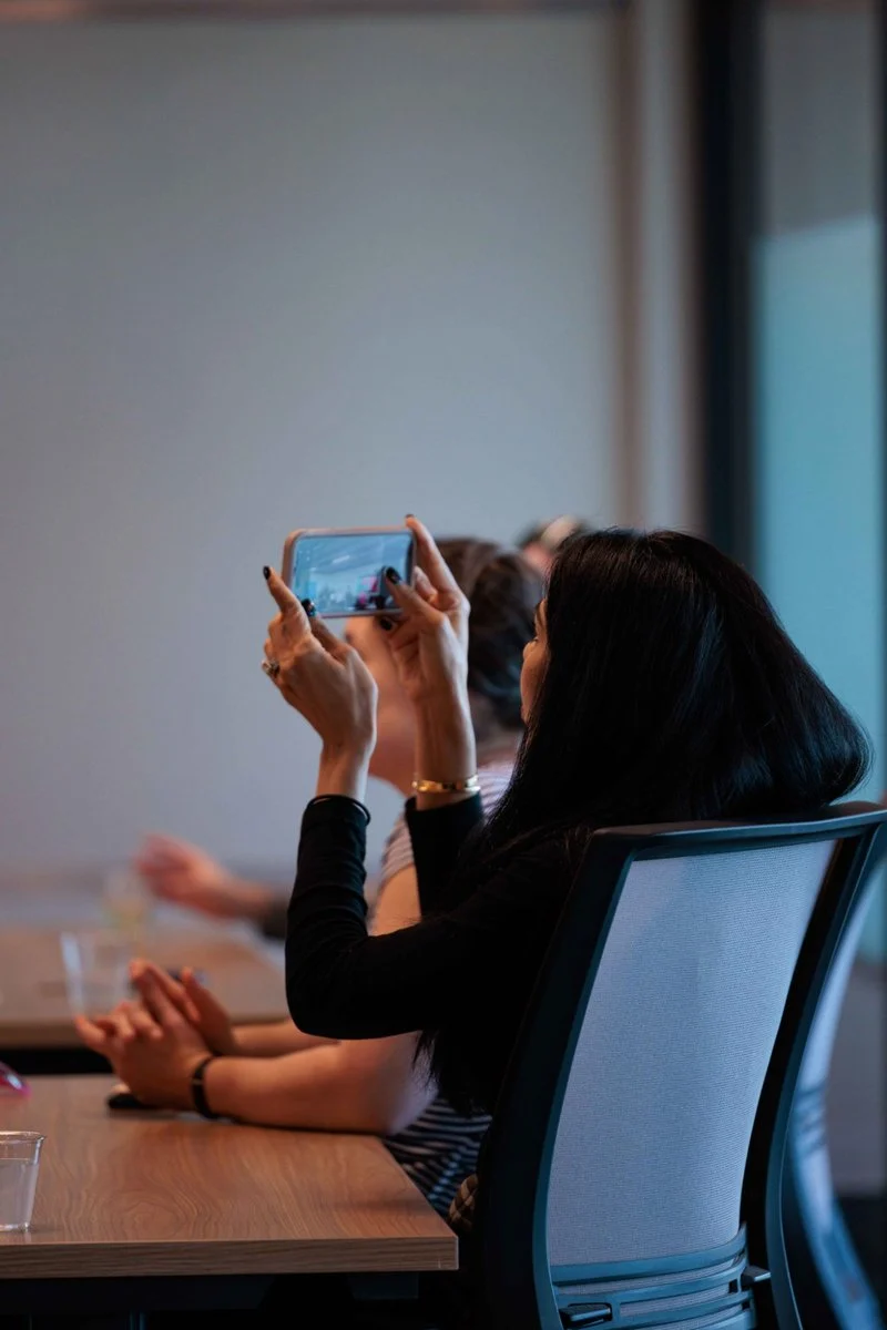 An attendee films the panel on her phone at AI ❤️ CX Atlanta