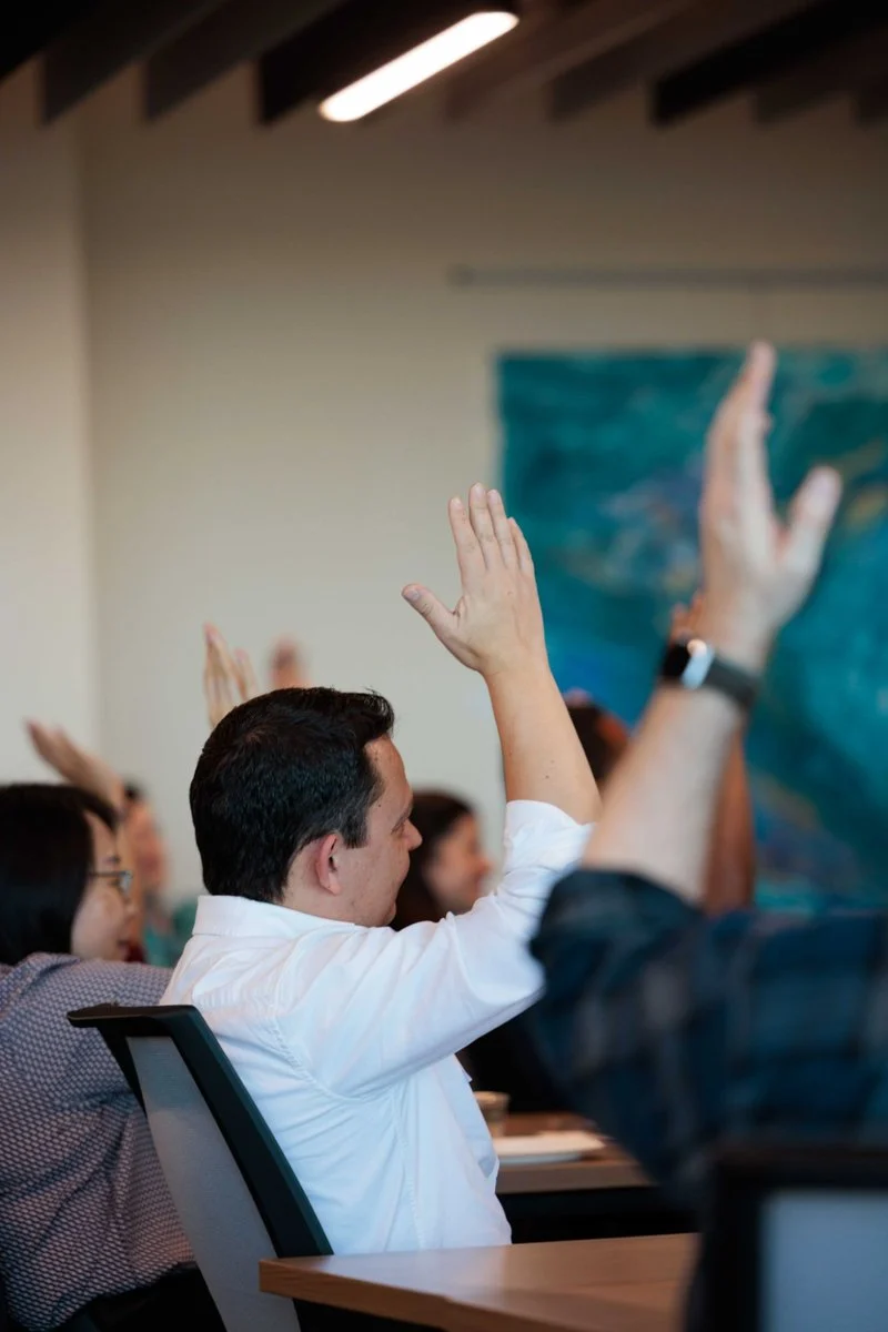 Audience members raise their hands in response to a panel question at AI ❤️ CX Atlanta