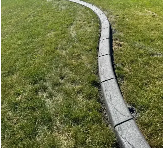 Smooth basic concrete curbing edging a garden bed
