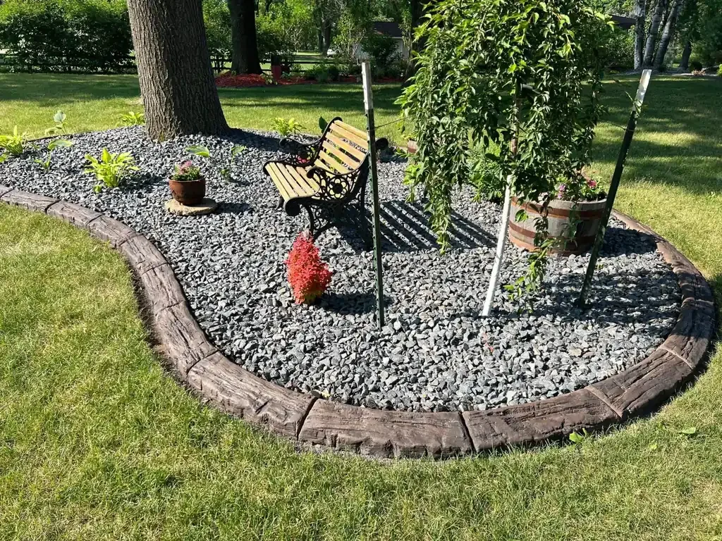 Stamped decorative concrete curbing bordering a landscaped garden bed