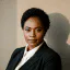 A confident Black woman with short curly hair in a dark suit, exuding professionalism and trust for any digital product.