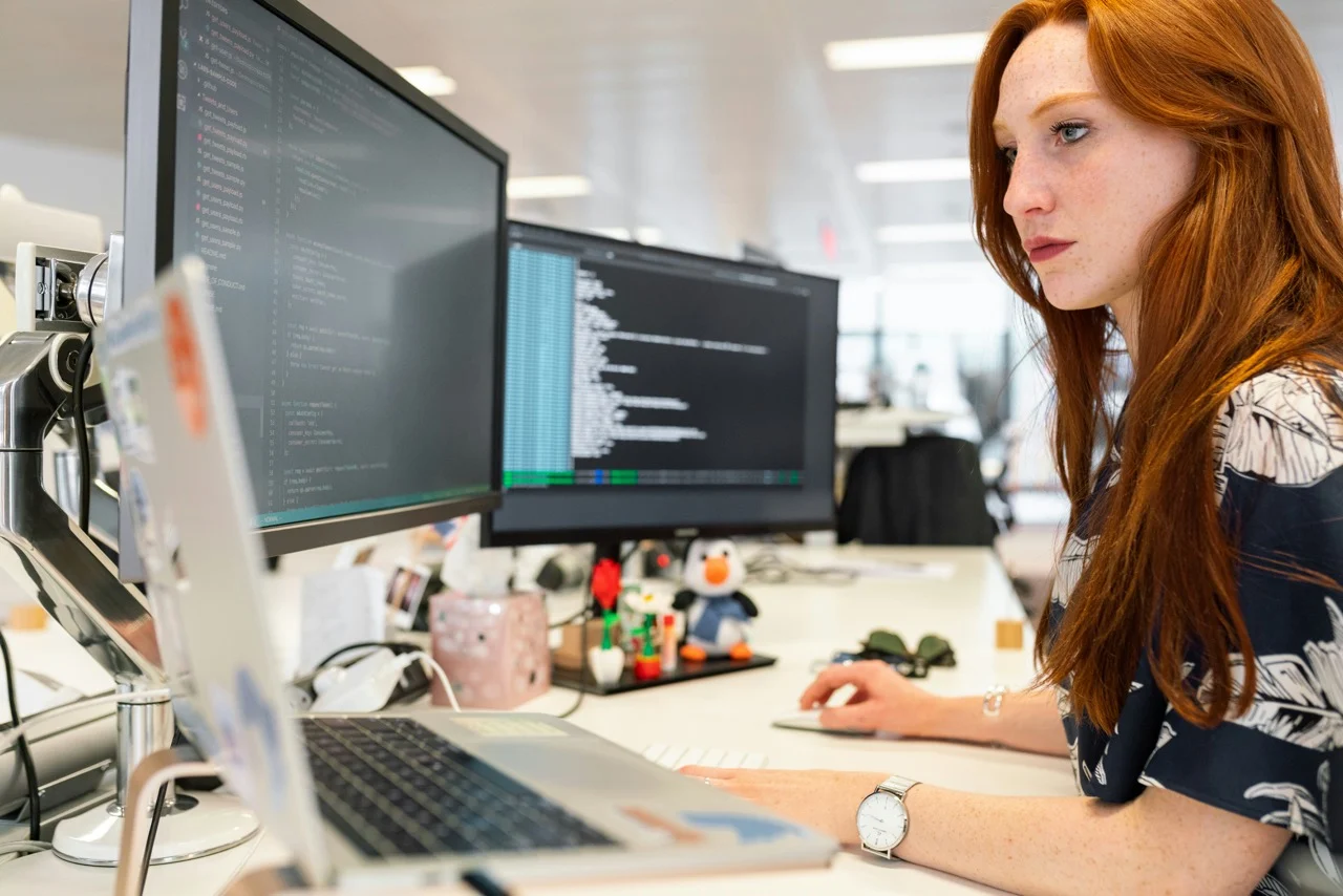 Software professional working at dual monitors in an office