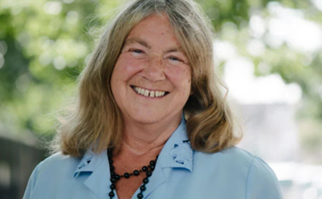 Elaine Storkey smiling, in a light blue blouse