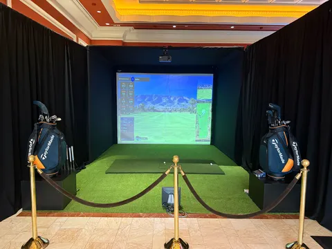 Premium Dryvebox indoor pop-up enclosure with TaylorMade bags at a corporate conference