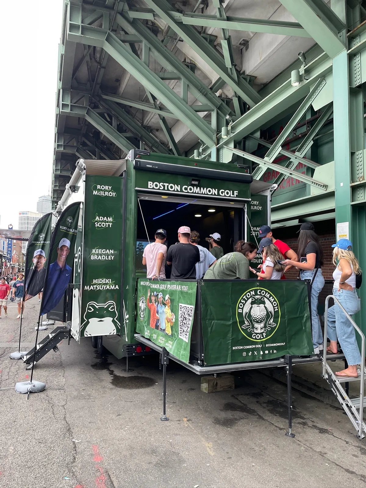 Boston Common Golf Dryvebox trailer under the stands at Fenway Park with fans lined up on the deck