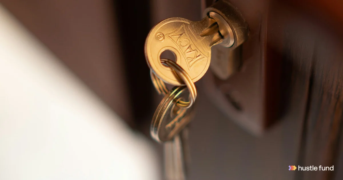 A gold key in a door lock, with the Hustle Fund logo in the corner