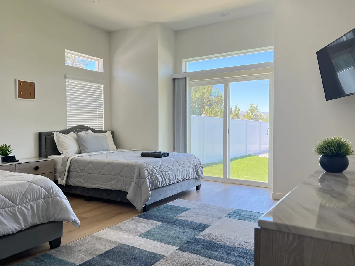Shared bedroom with two beds and sliding glass doors to the grounds