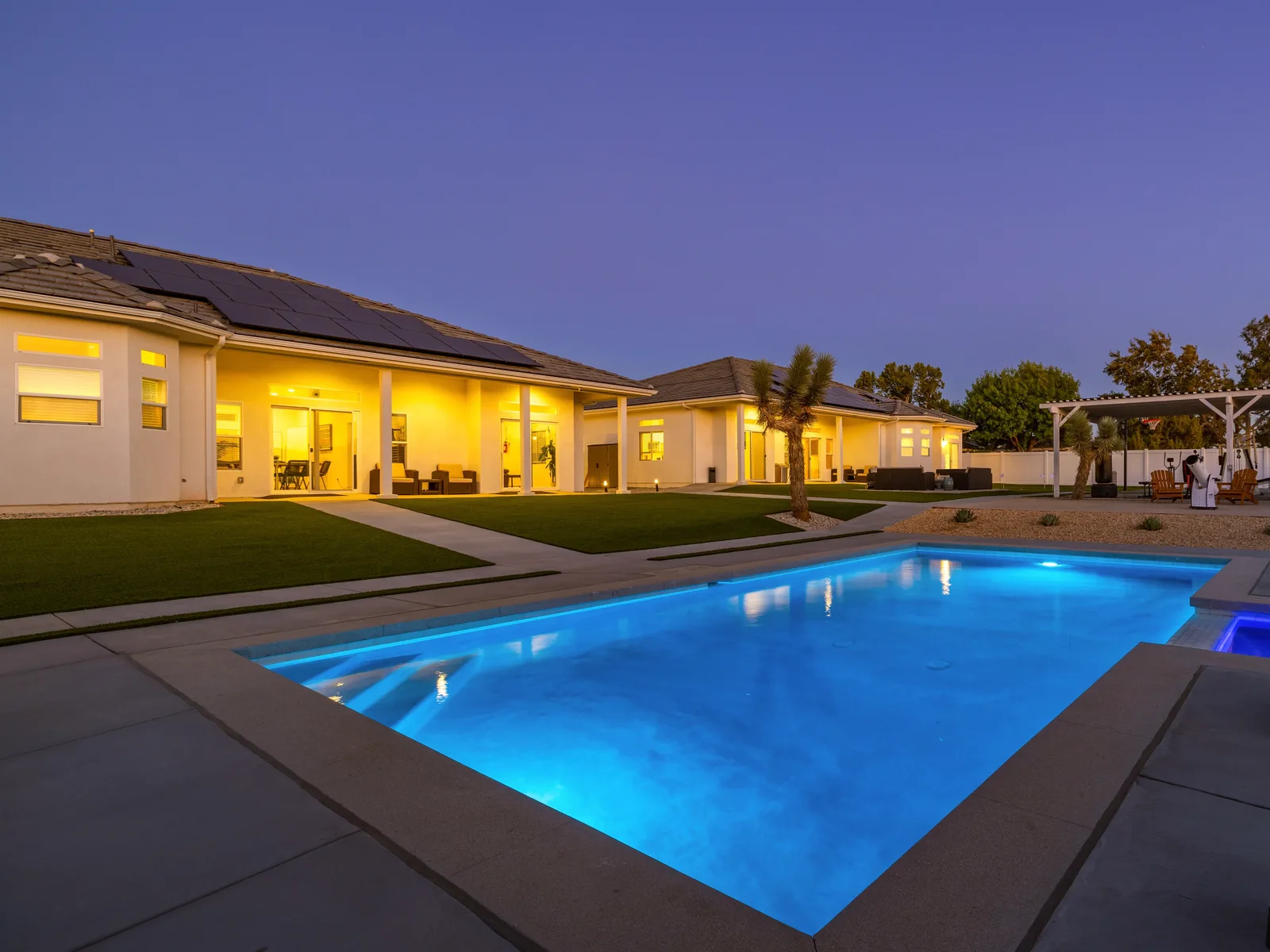 Illuminated swimming pool and residential buildings at dusk