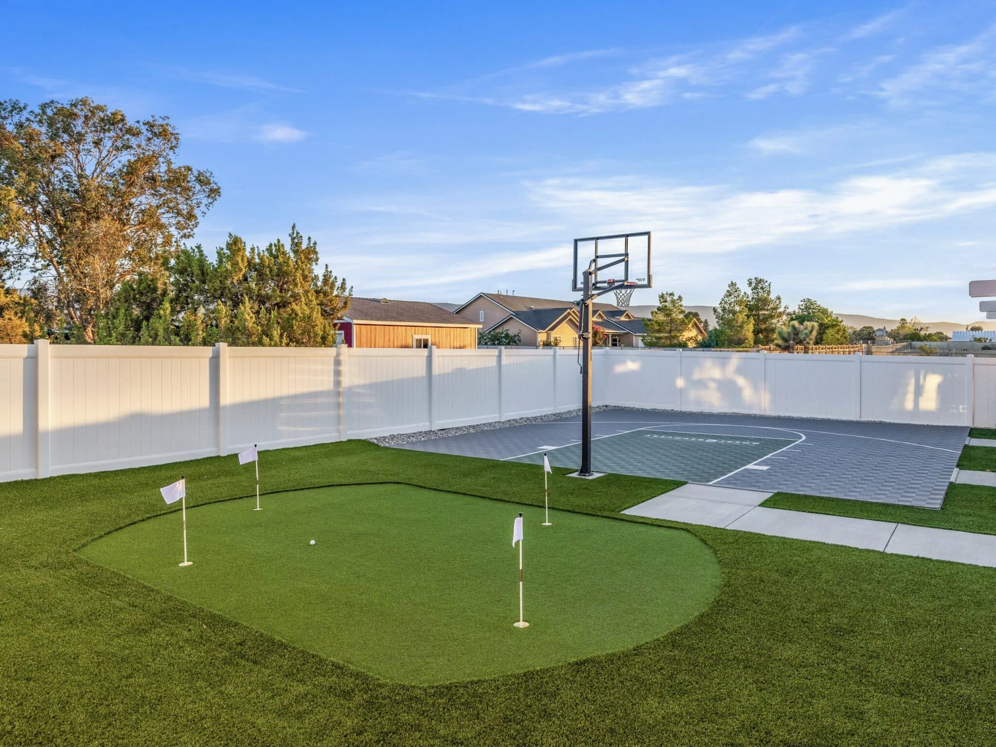 Outdoor recreation area with a putting green and basketball court