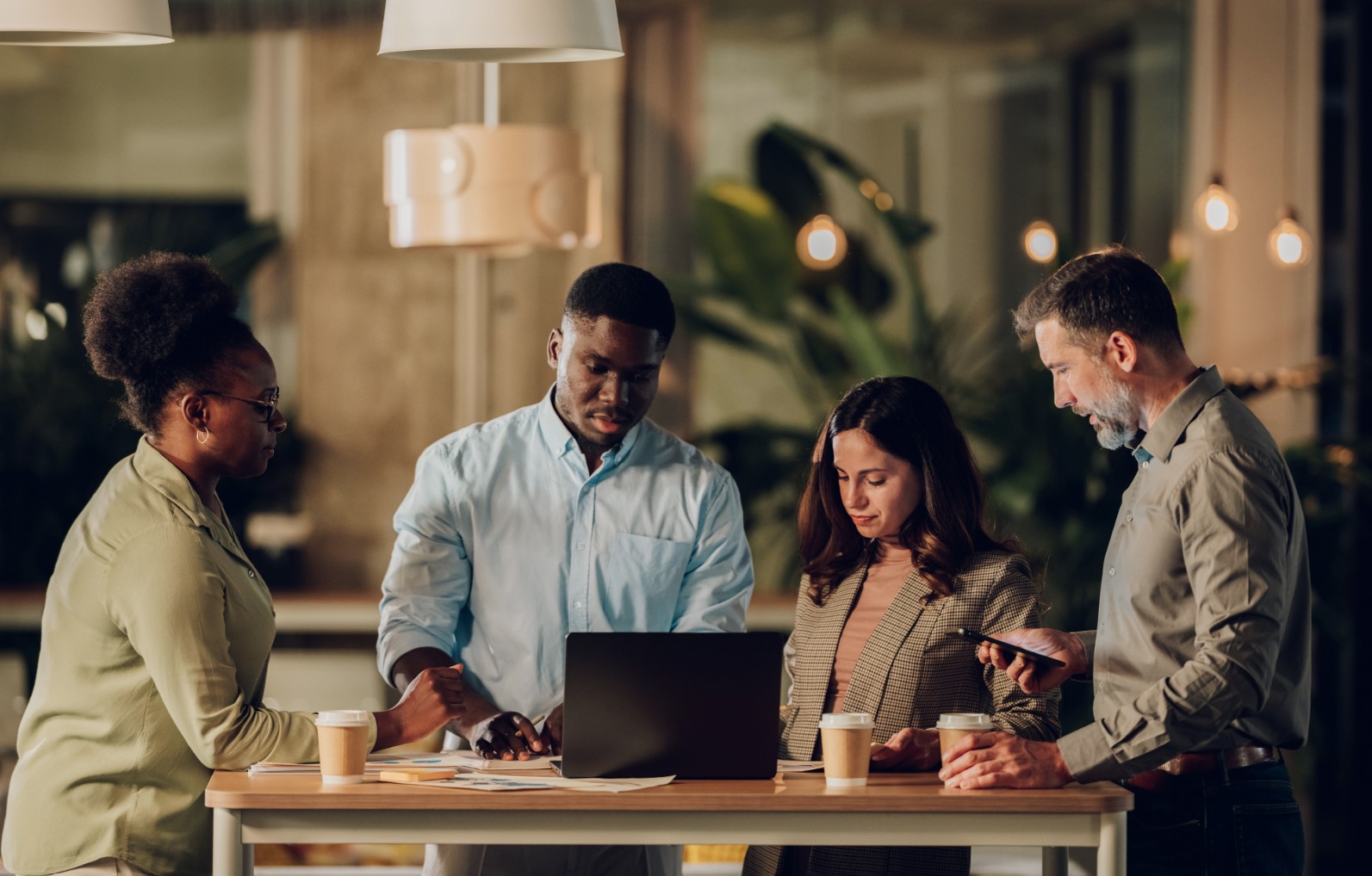 A team reviewing content together around a laptop