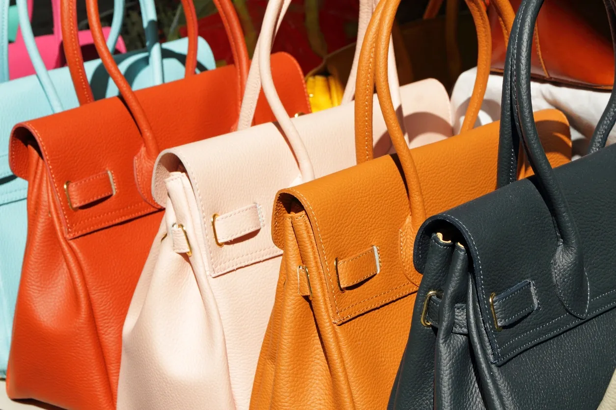 A row of colorful designer leather handbags