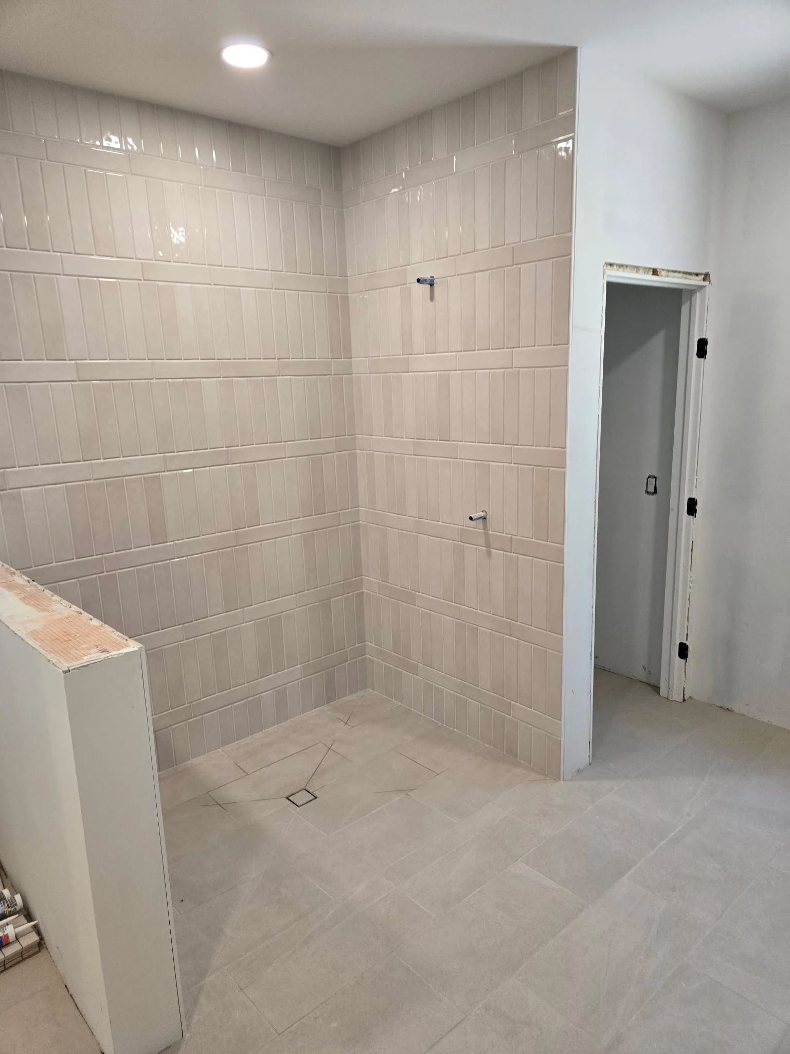 Walk-in shower walls set in large format tile before fixtures