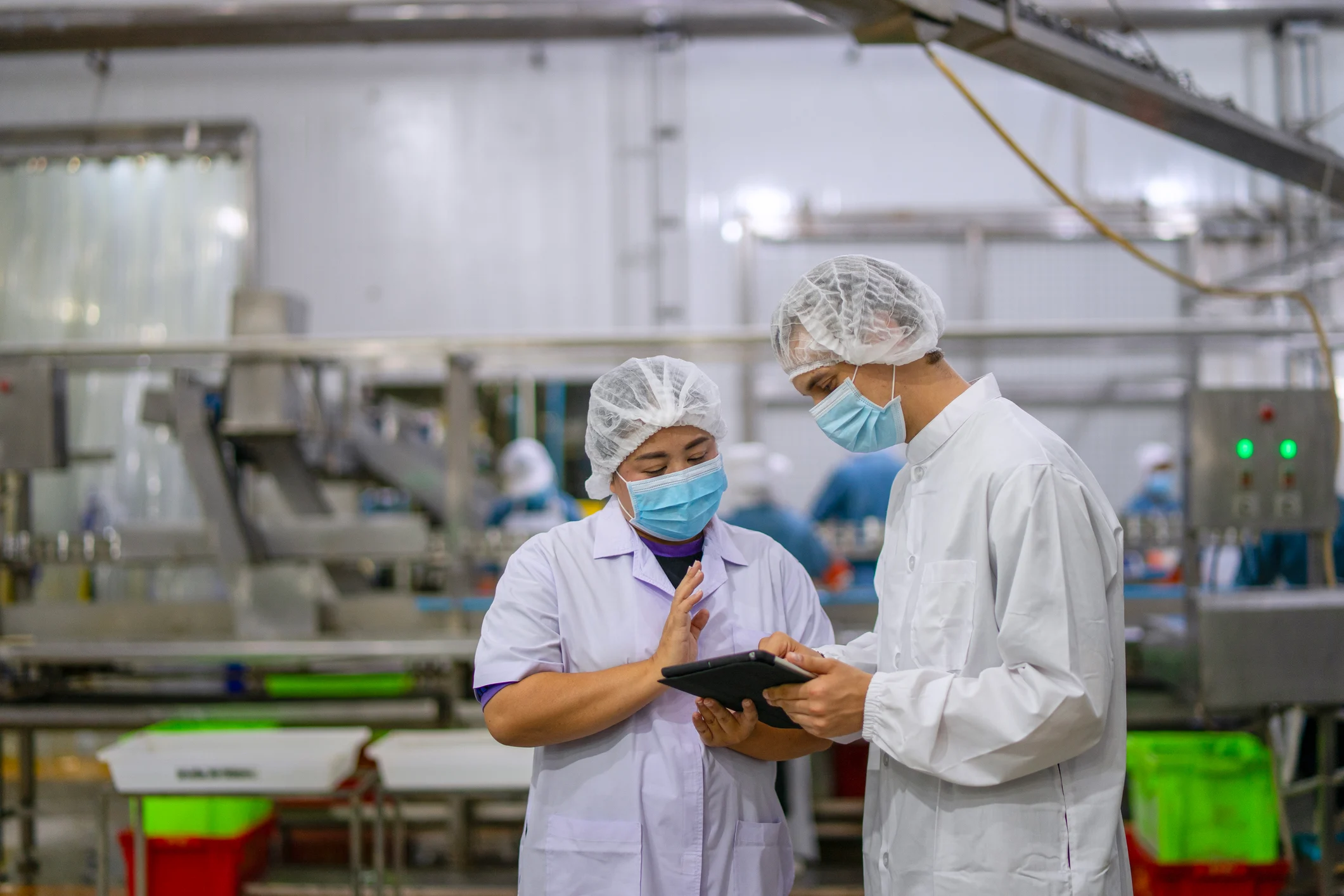 Food production facility team members reviewing sanitation operations on a tablet