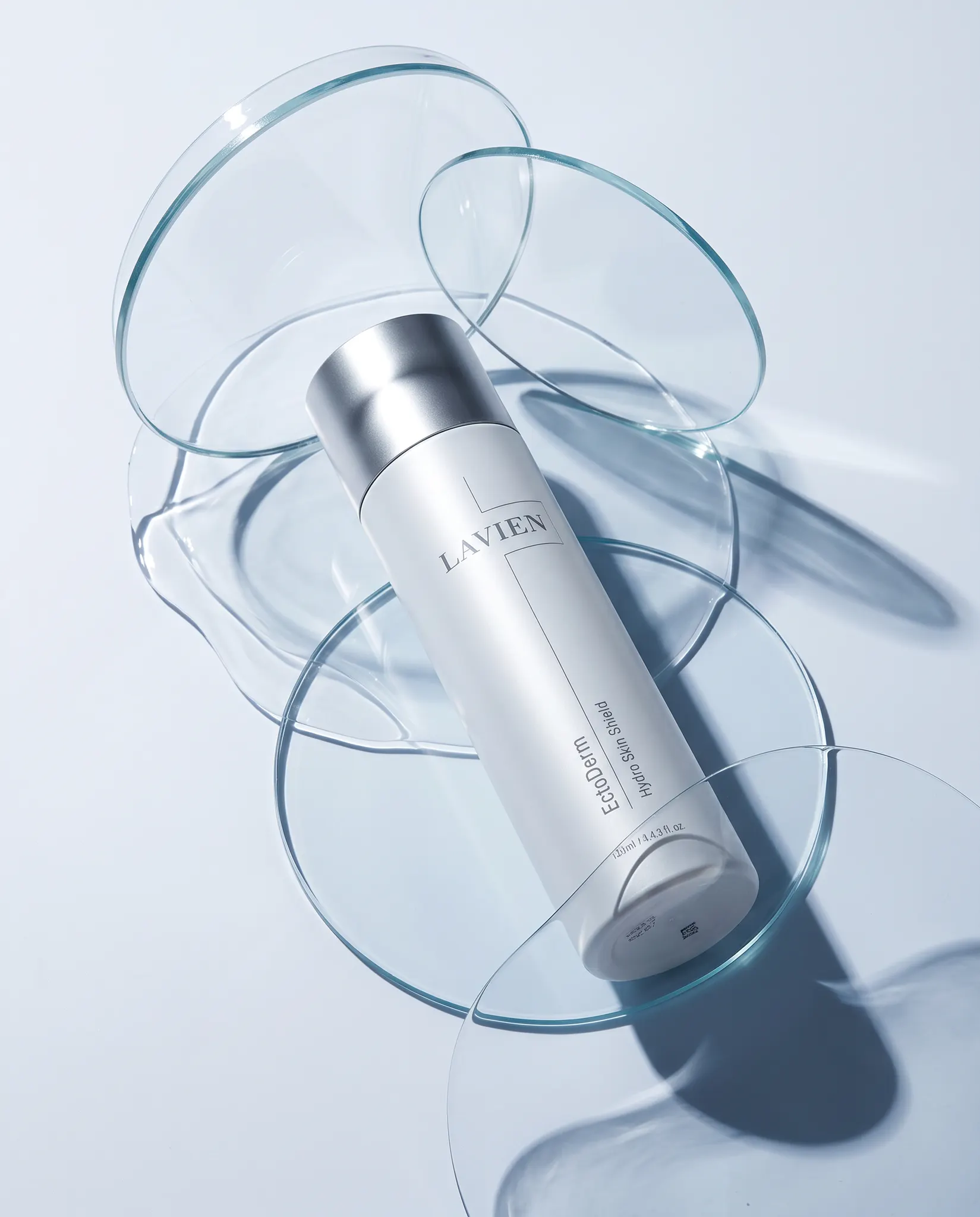 LAVIEN EctoDerm Hydro Skin Shield bottle among translucent glass ribbons