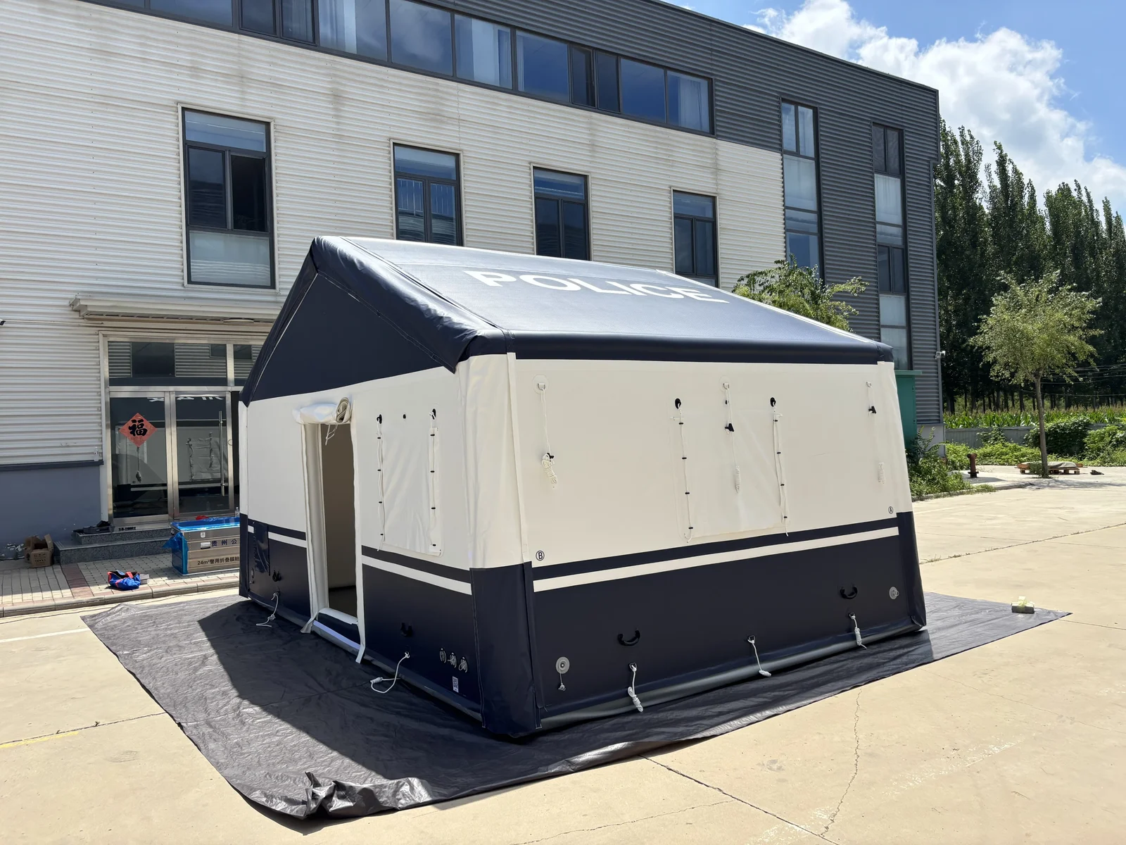 Navy and white drop-stitch inflatable tent shown outdoors with an open entrance