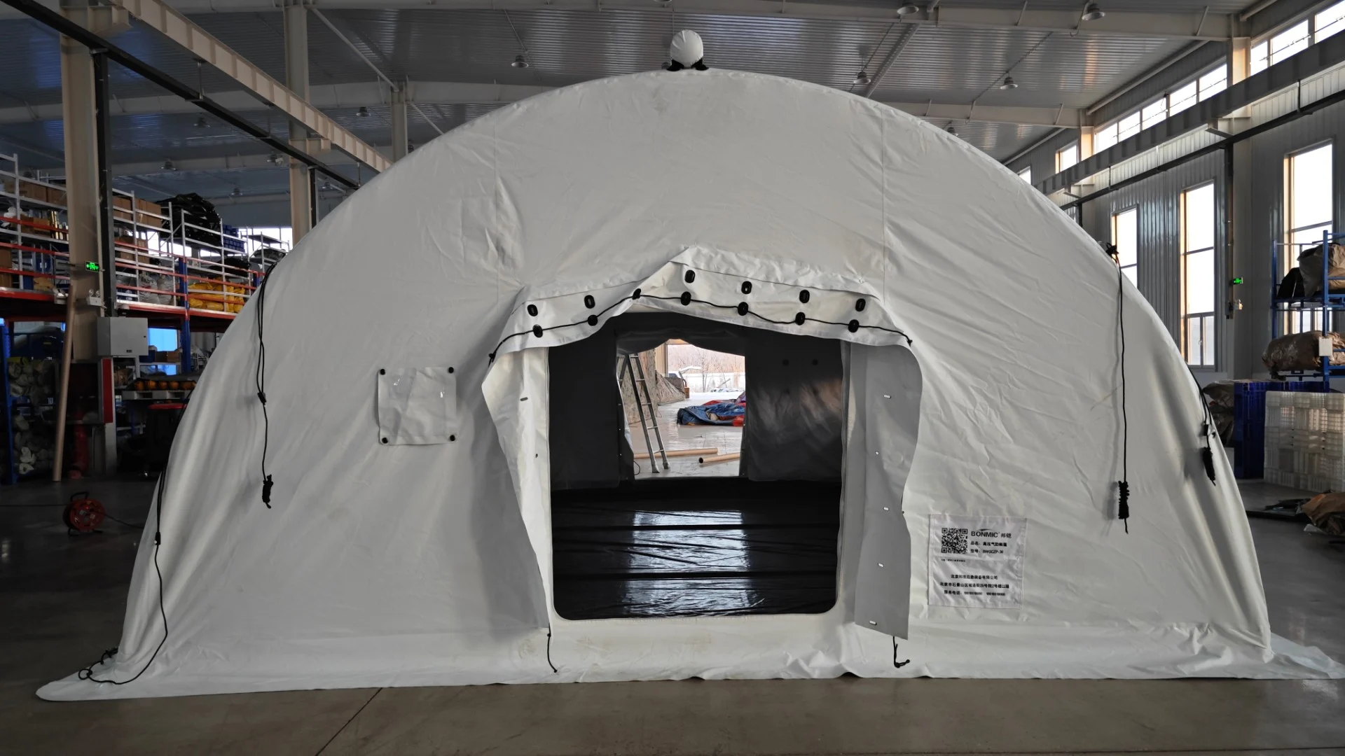 White high-pressure inflatable tent from the front with an open entrance and visible interior flooring