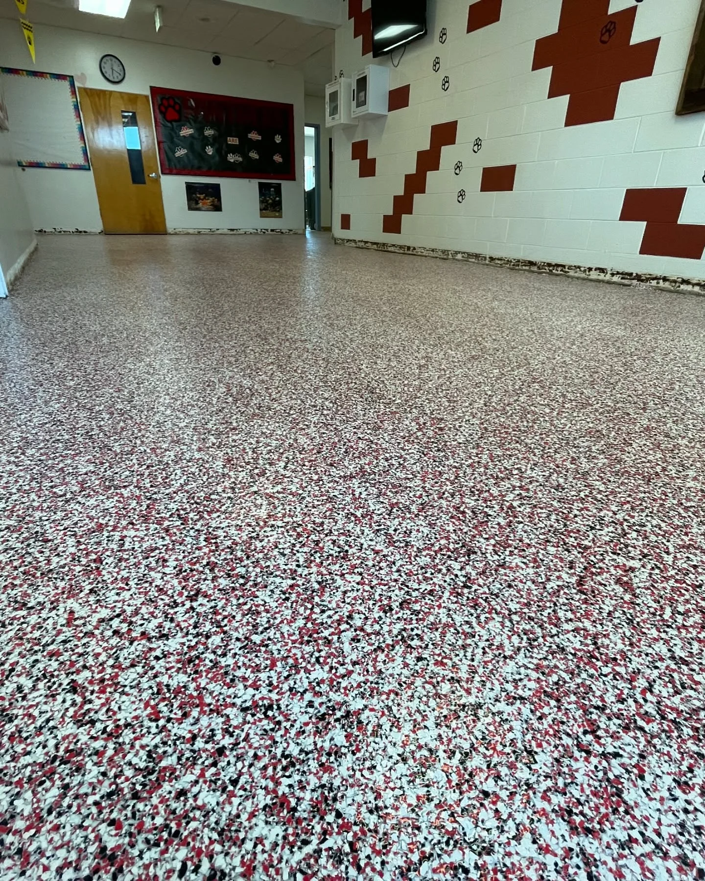 Red, white, and black flake floor in a hallway