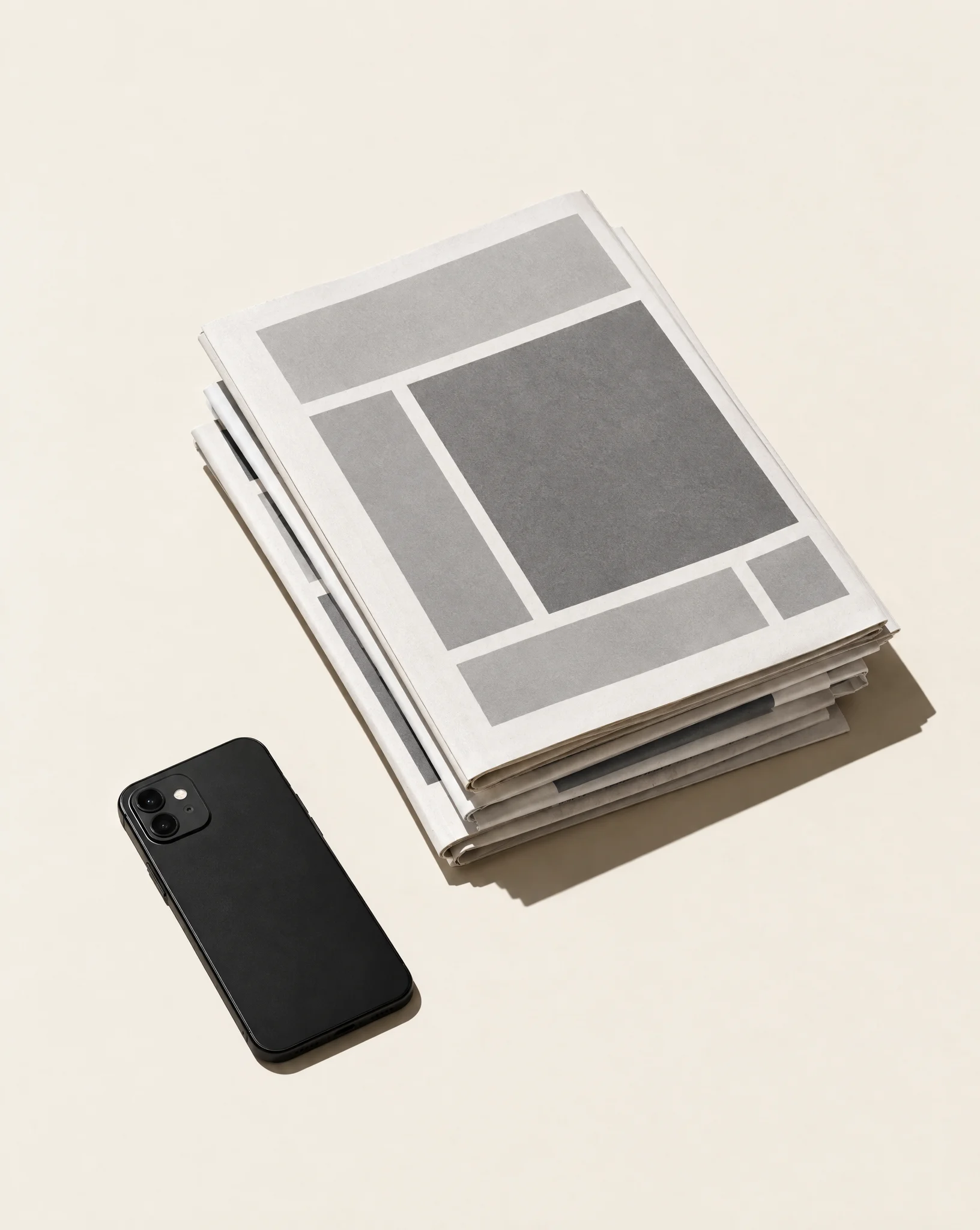 A stack of printed newsletters beside a phone.