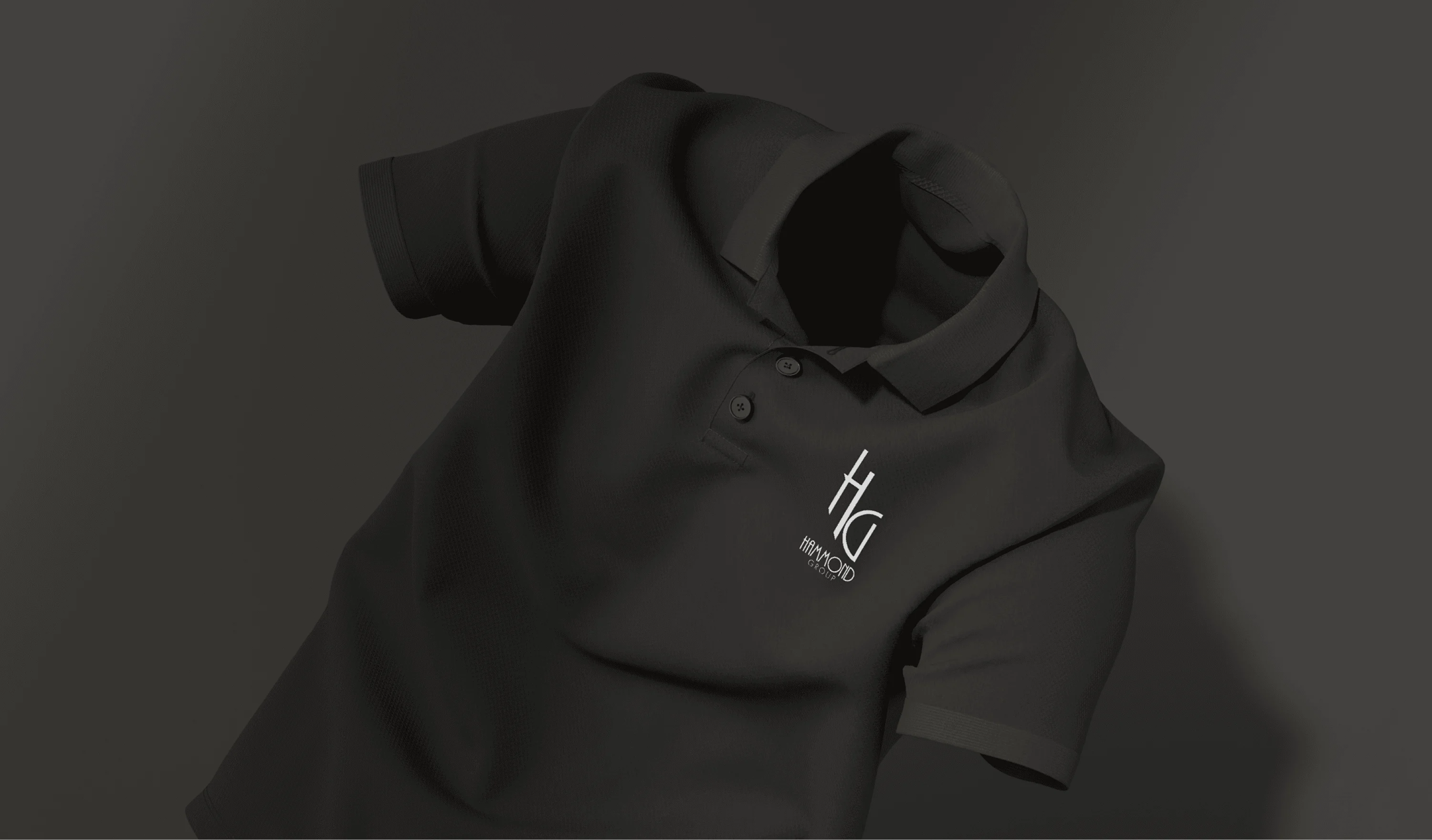 A black Hammond Group polo with the HG monogram.