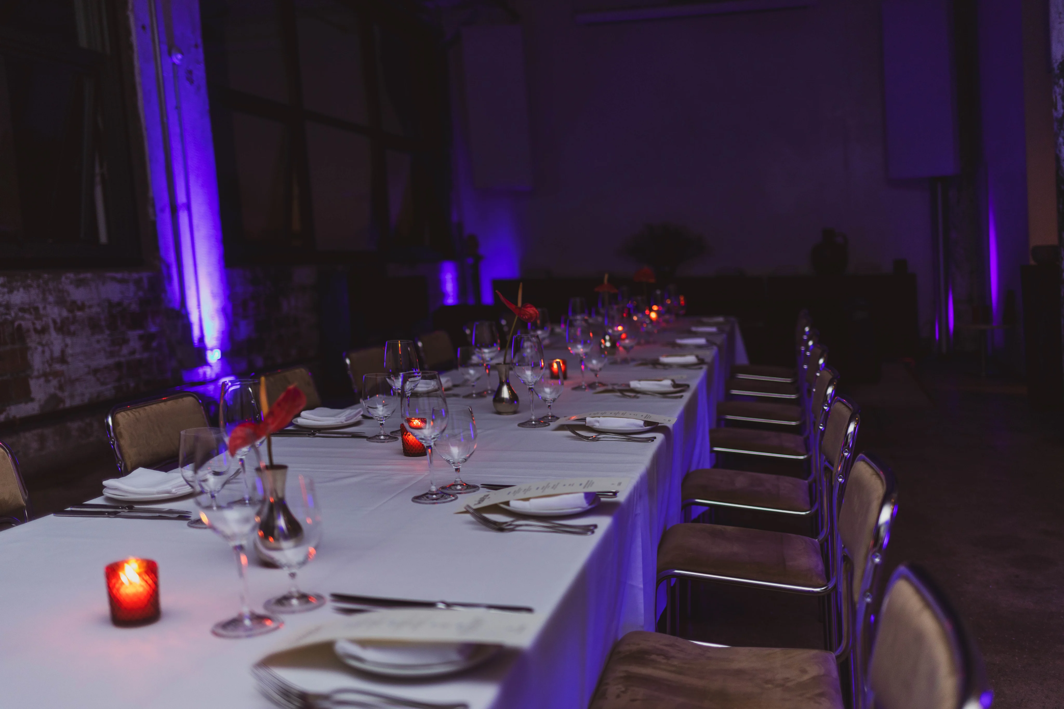 A candlelit long table set for a WealthPlan Club members' dinner.