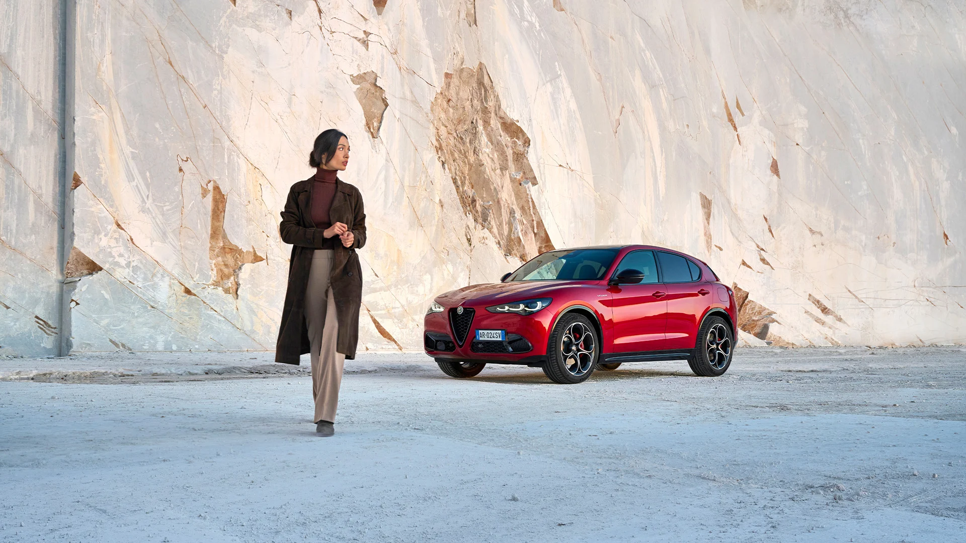 Roter Alfa Romeo Stelvio vor einer hellen Marmorwand
