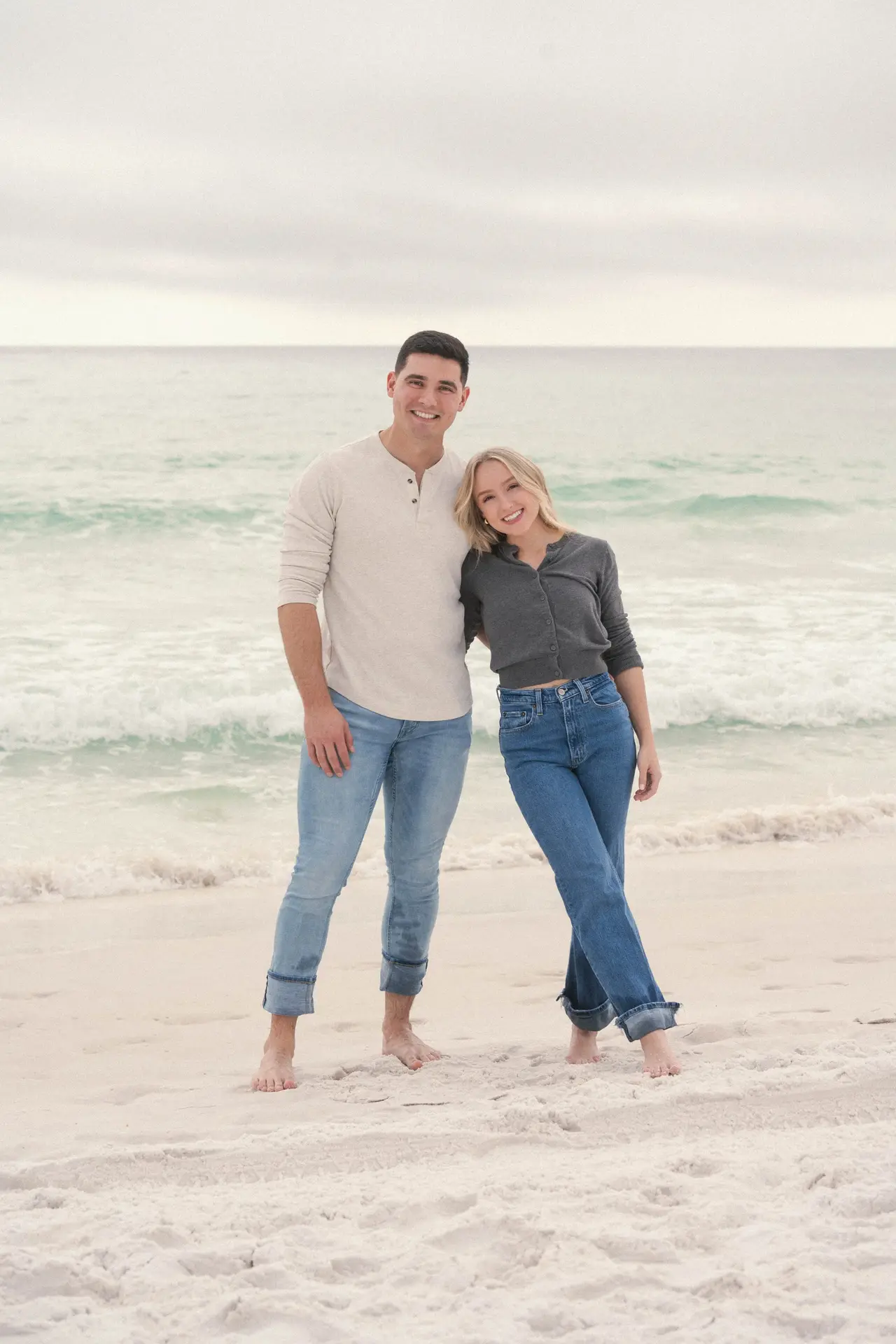 Derrick and Emily Sumner standing together on the beach in front of the Gulf