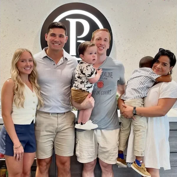 Derrick and Emily with a young family holding their two little boys after closing.