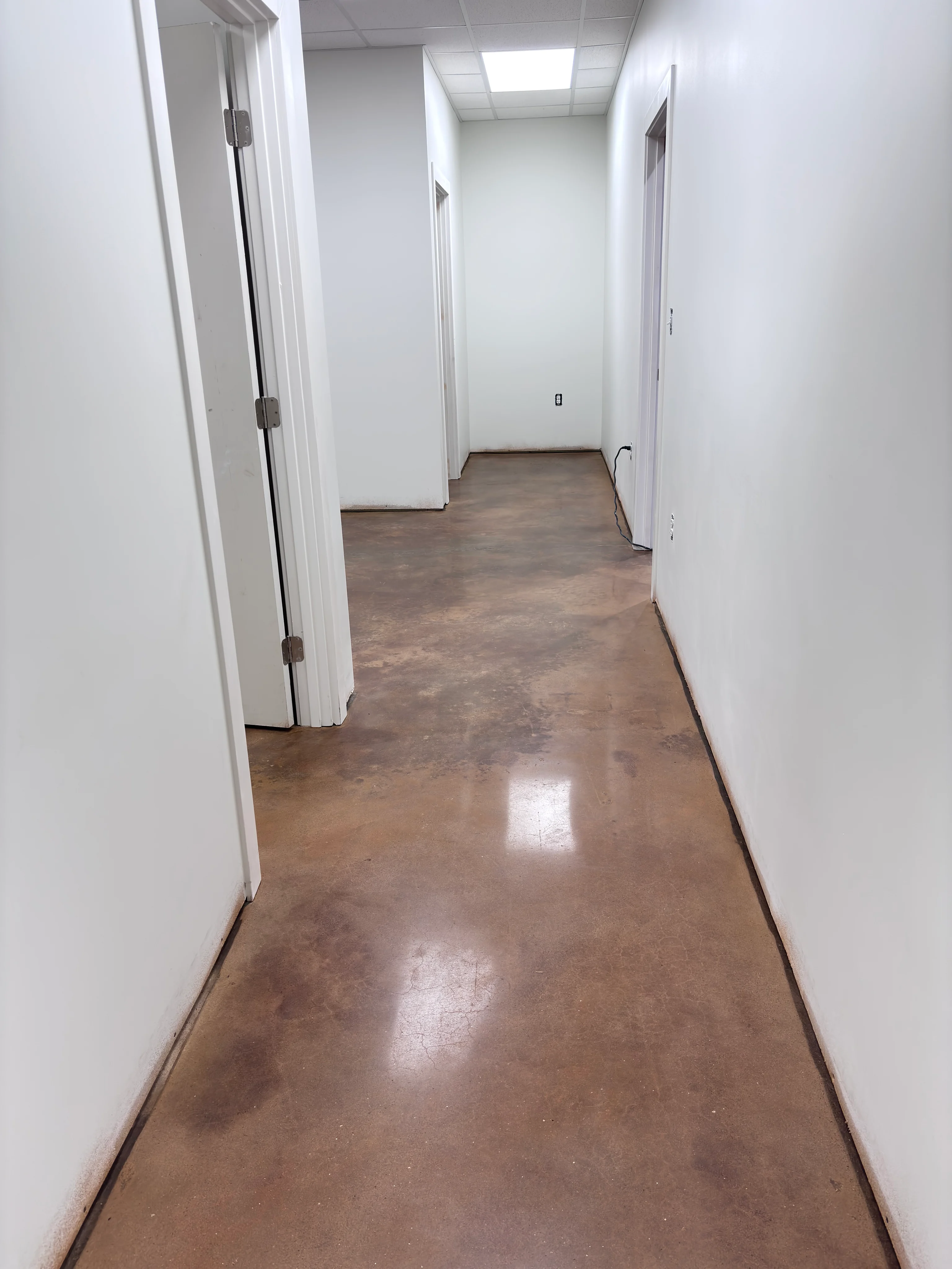 Polished brown concrete floor in an office hallway