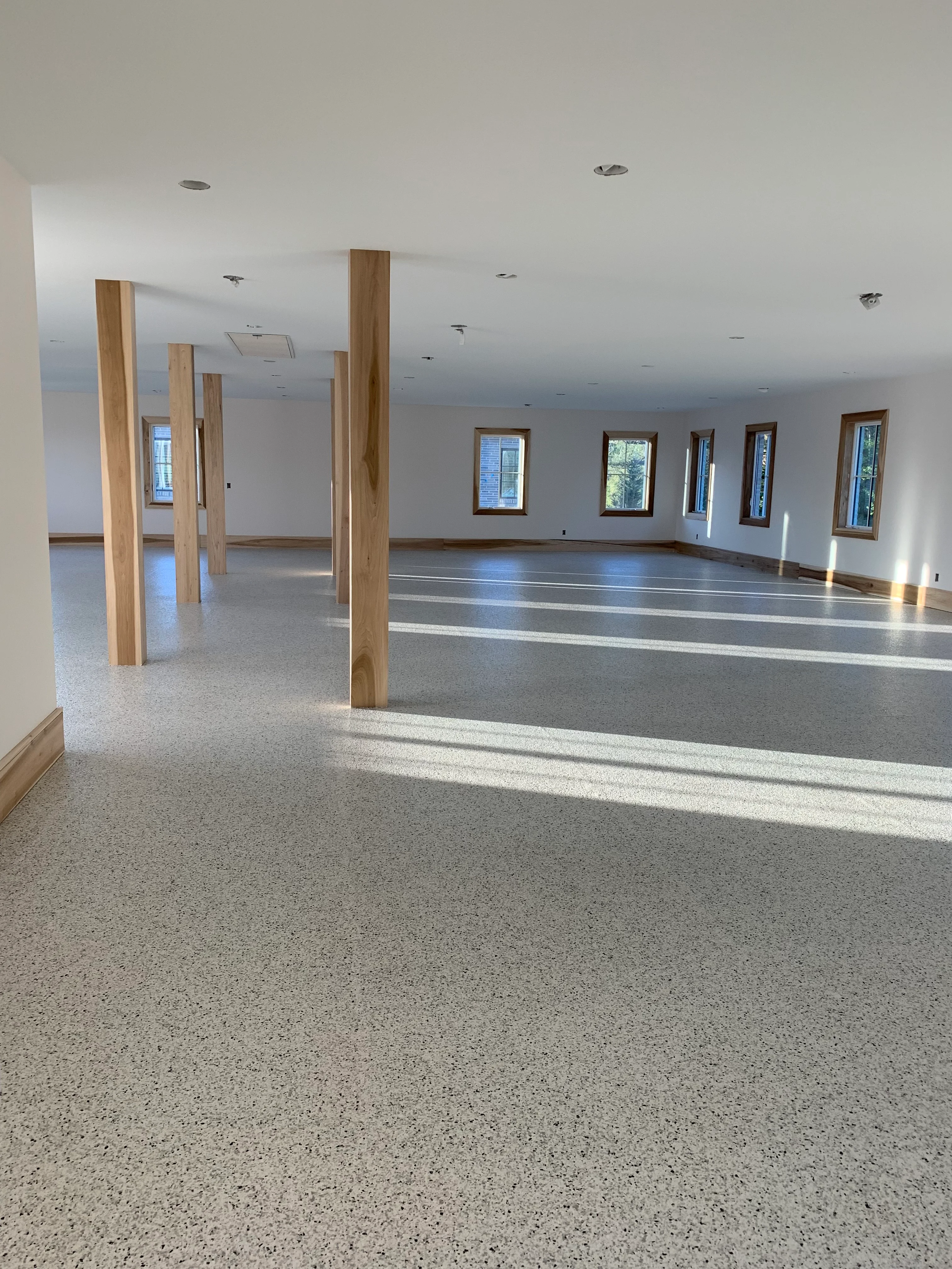 Speckled floor in a bright room with wood columns
