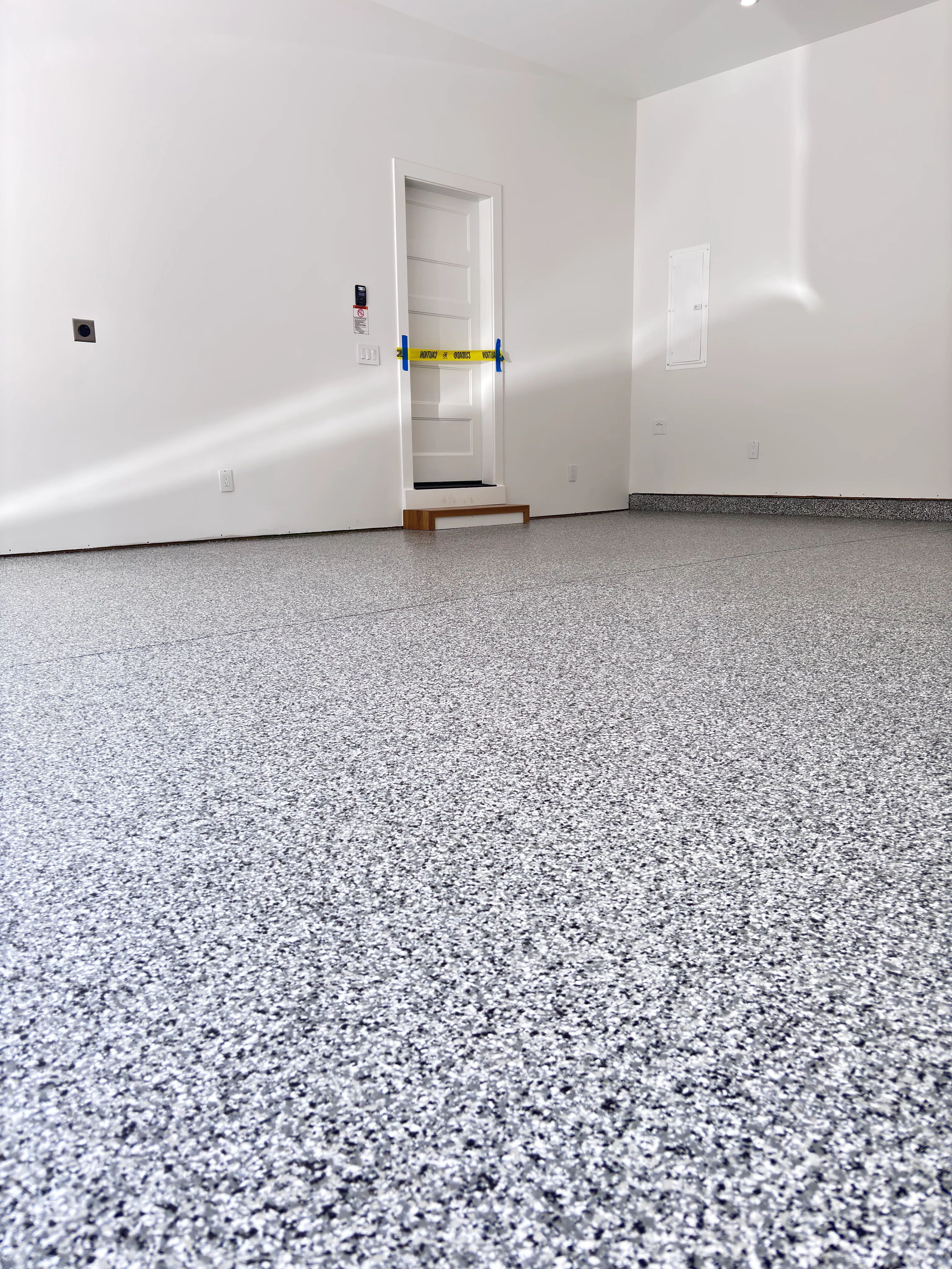 New gray and white speckled epoxy coating in an empty garage