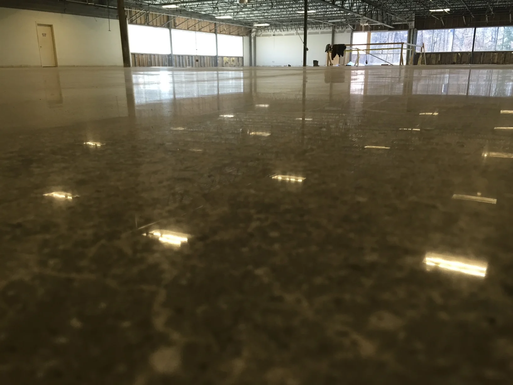 Reflective concrete floor in a commercial interior under renovation