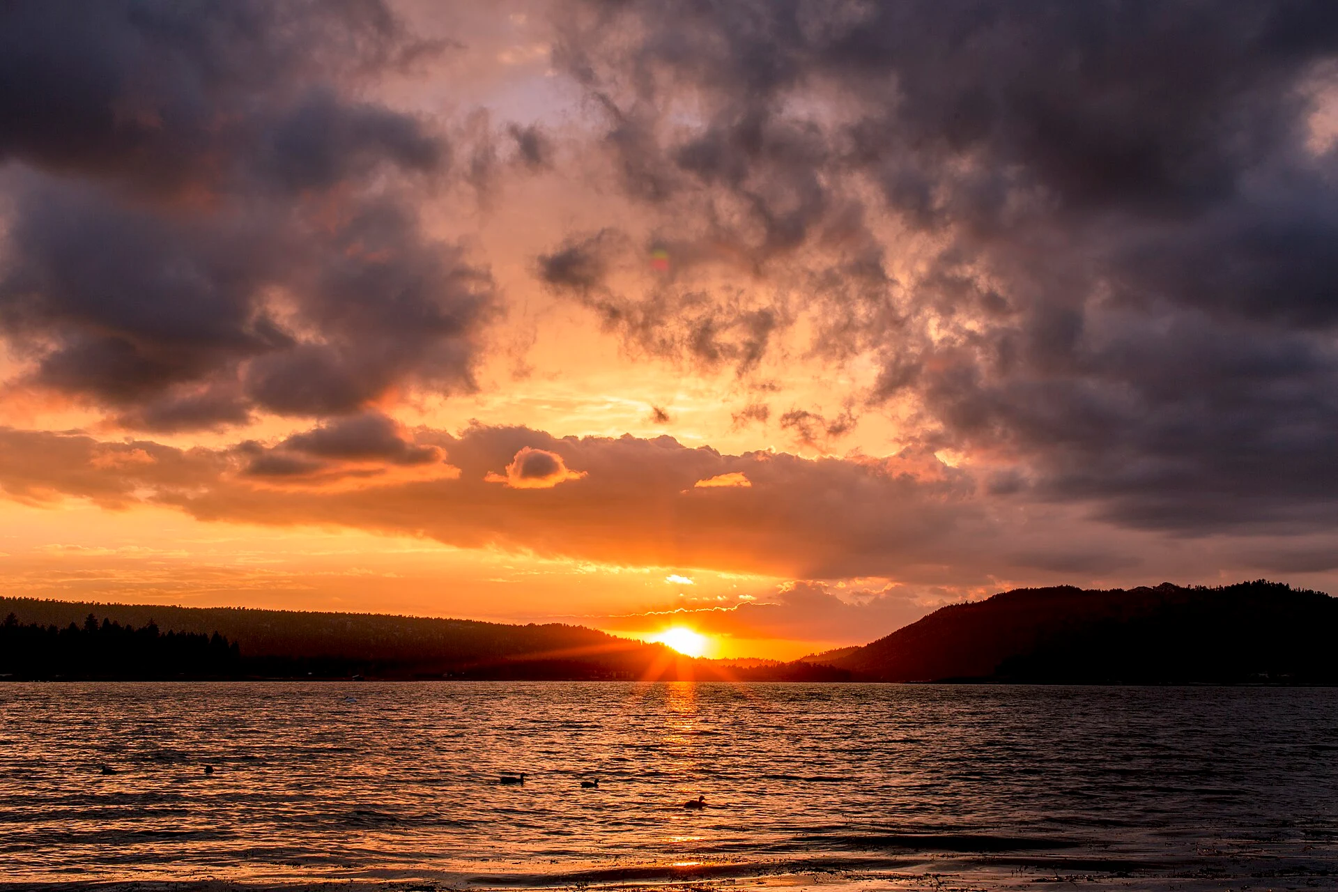Sunset over Big Bear Lake with mountain silhouettes and waterfowl
