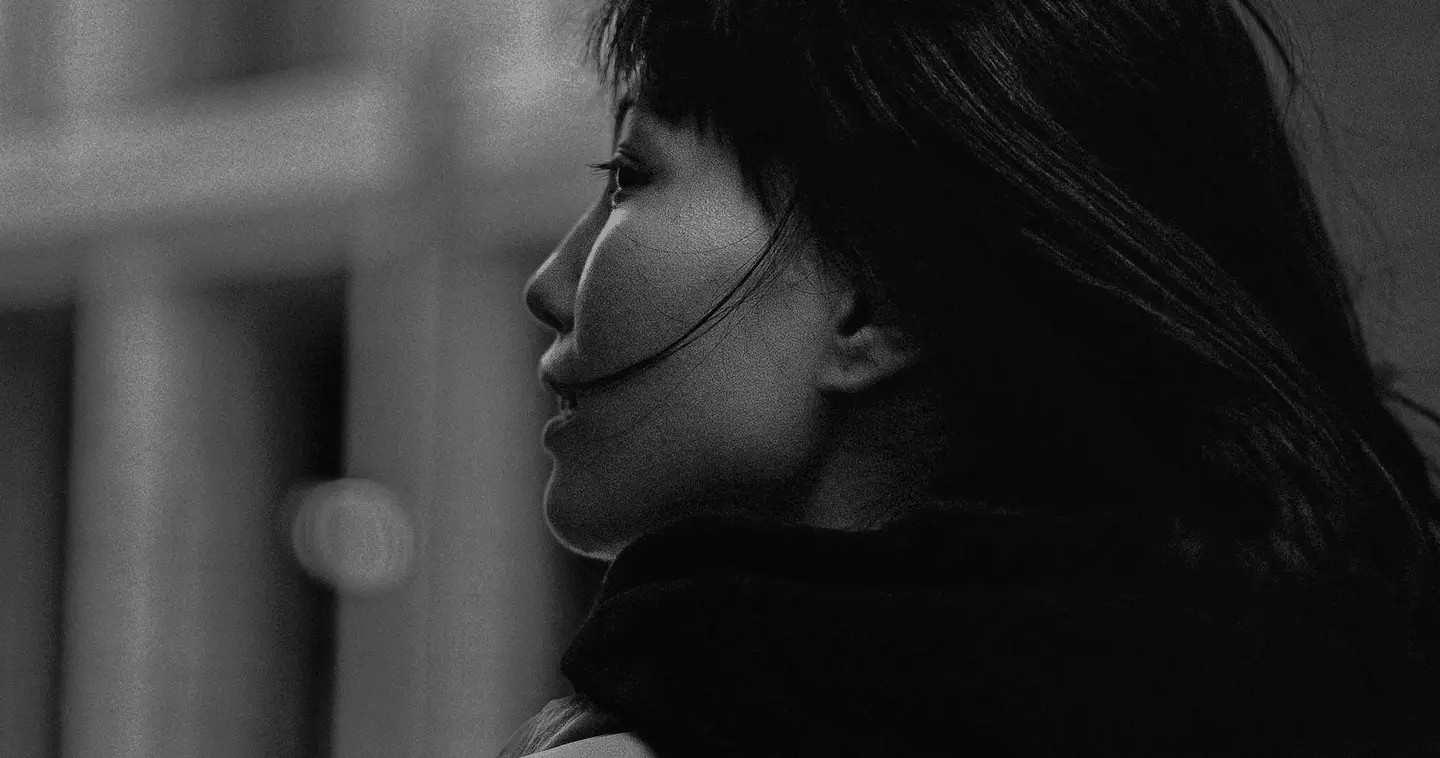 Black-and-white close-up profile of a woman with flowing hair looking to the left.