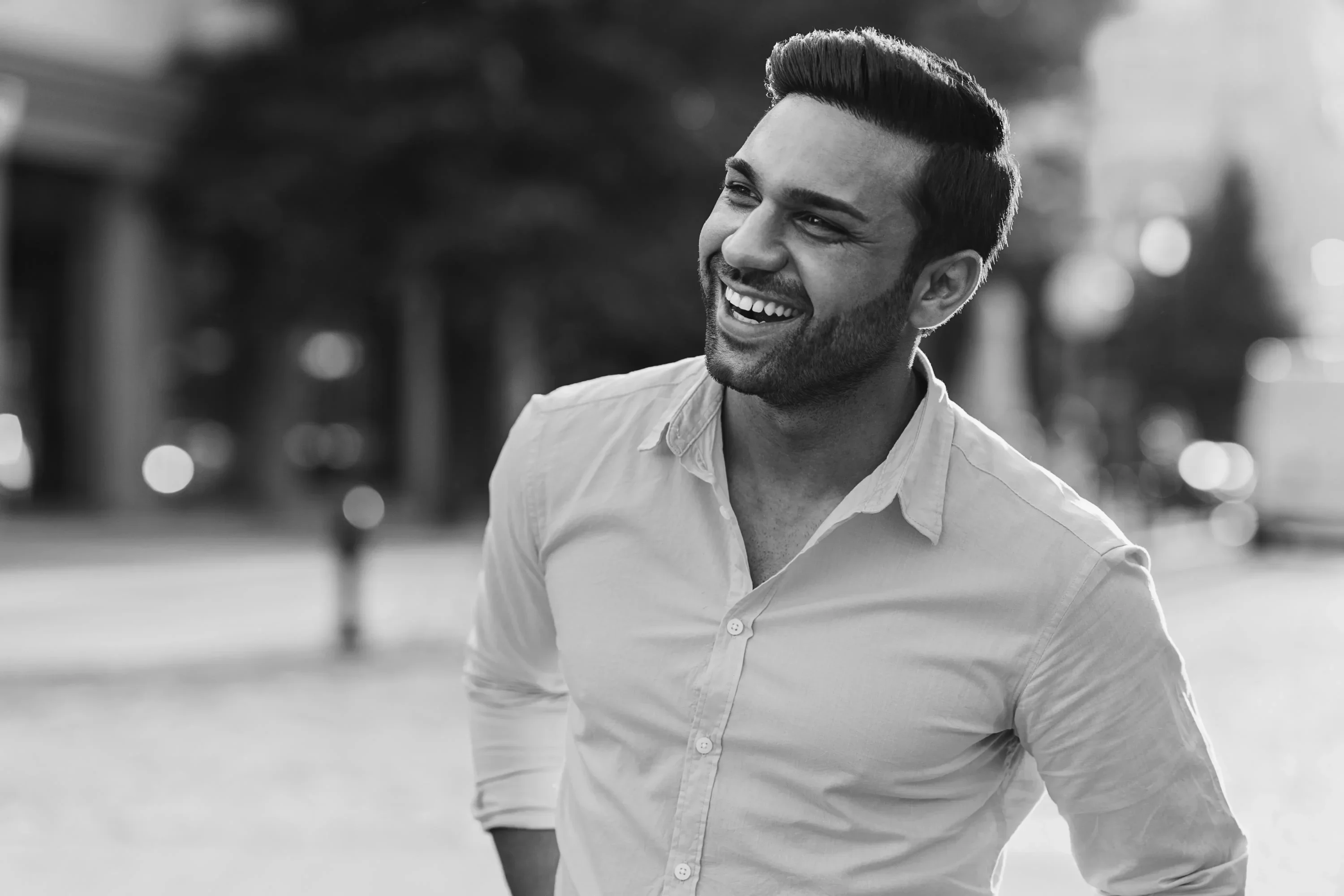 Black-and-white portrait of a recruiting leader smiling against a city background.