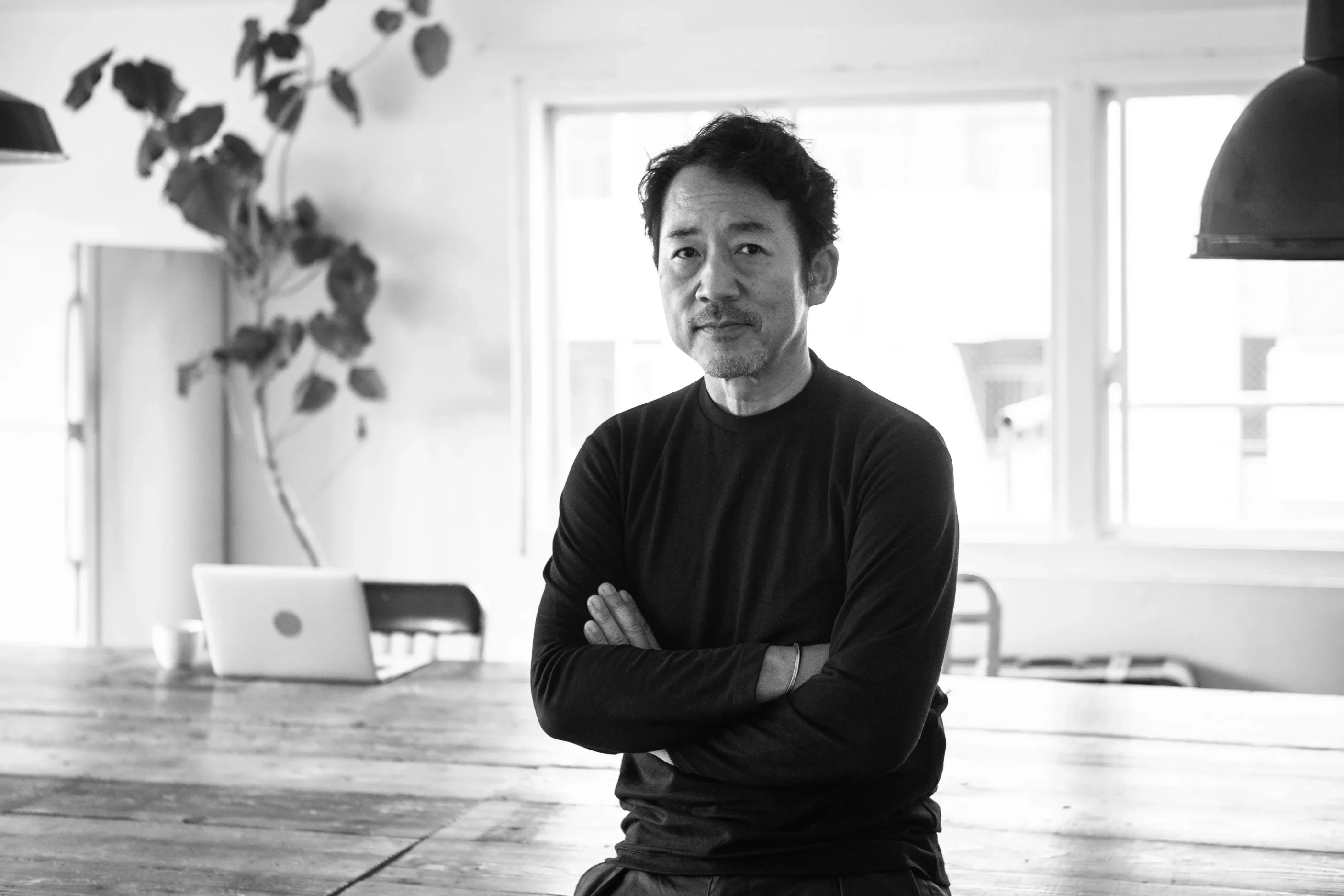 Black-and-white portrait of an enterprise leader standing with arms crossed.