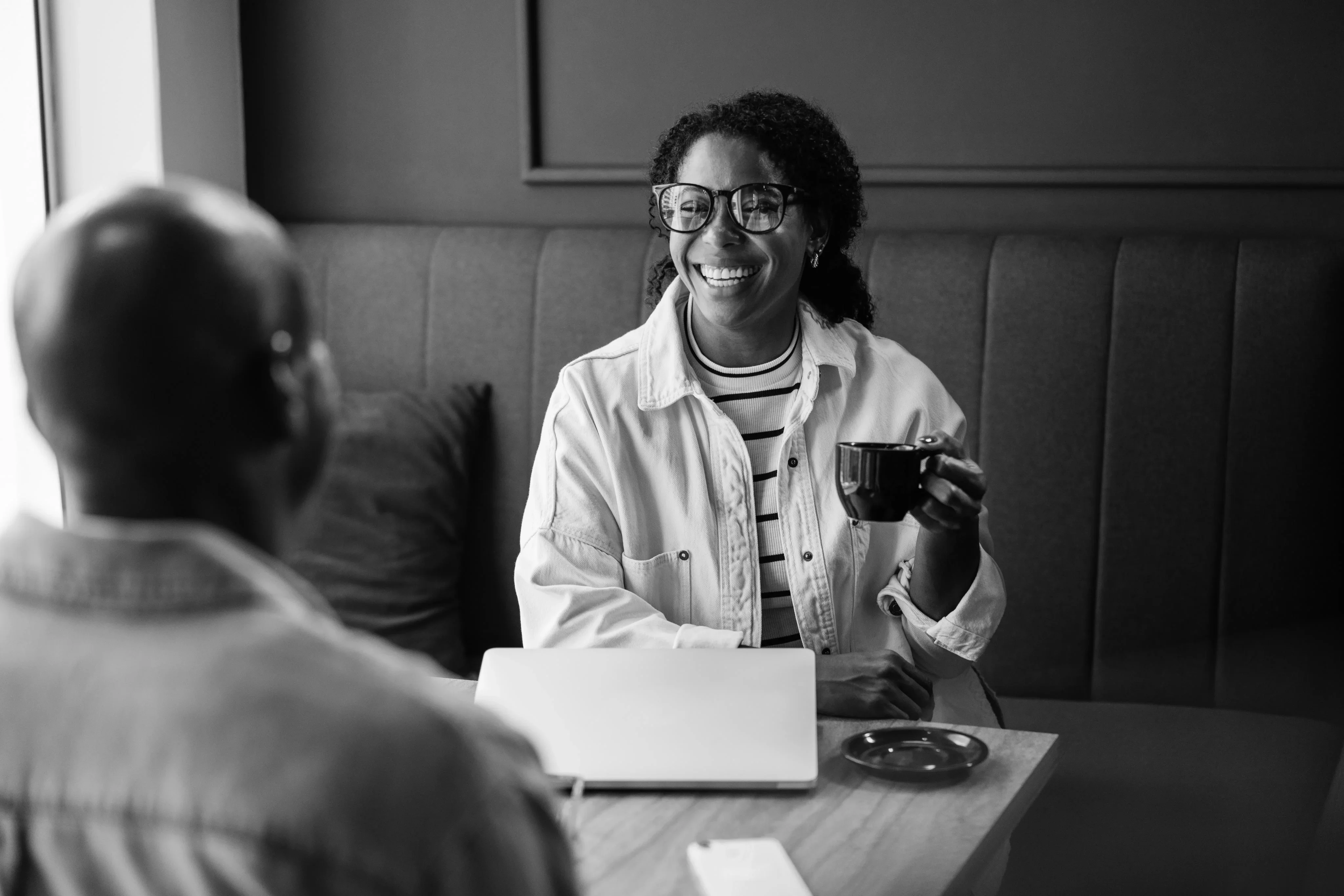 Black-and-white portrait of a talent leader in conversation at a cafe table.
