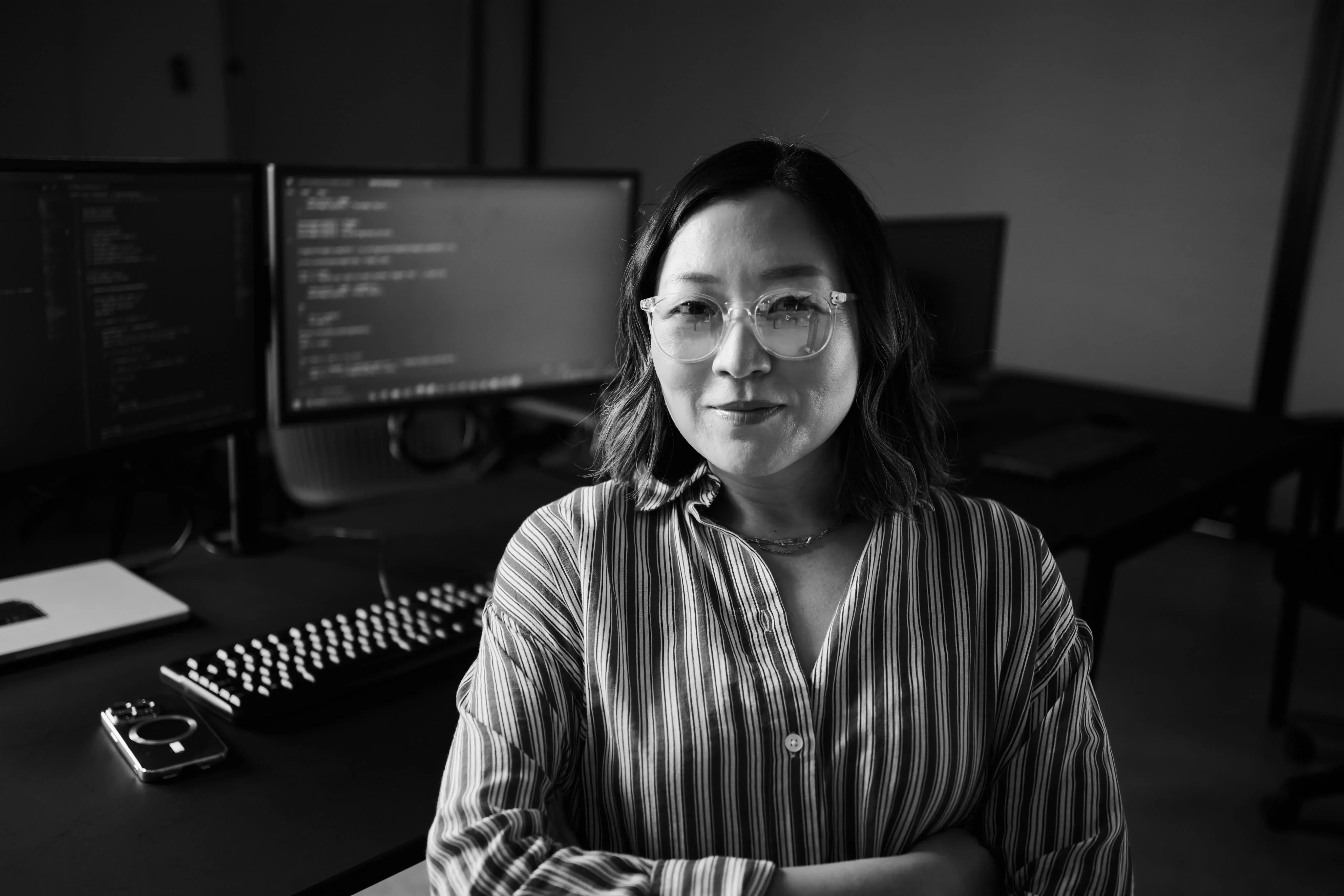 Black-and-white portrait of a technical leader at a workstation.