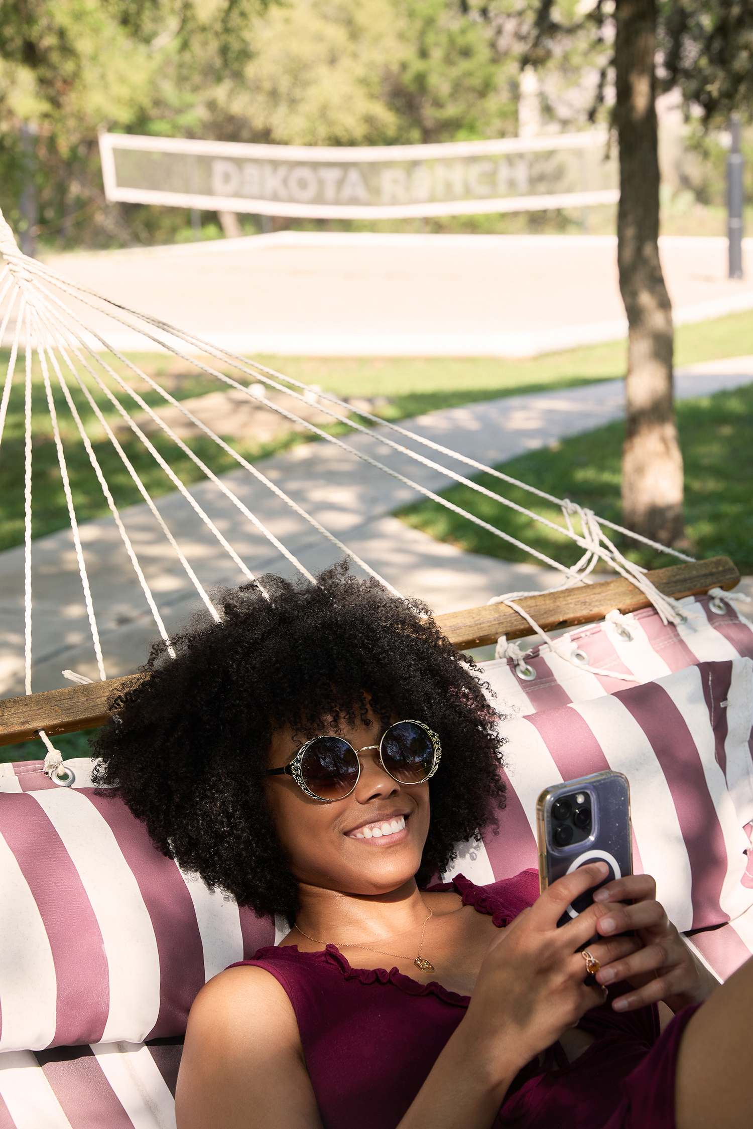 Resident smiling at her phone in a hammock at Dakota Ranch, from a Studio + Commerce lifestyle shoot