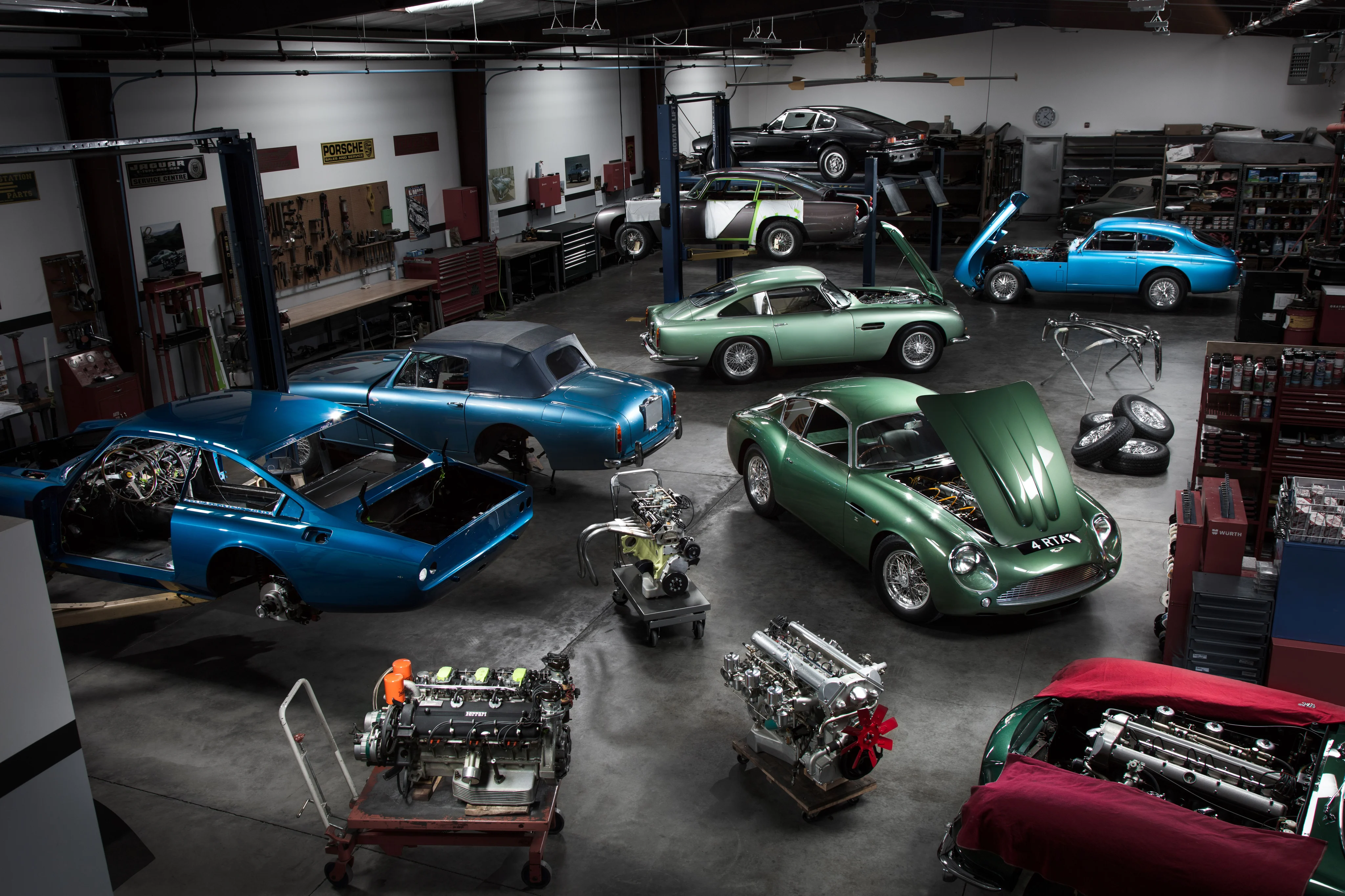 Classic British and European cars undergoing restoration inside the Kevin Kay Restorations main shop