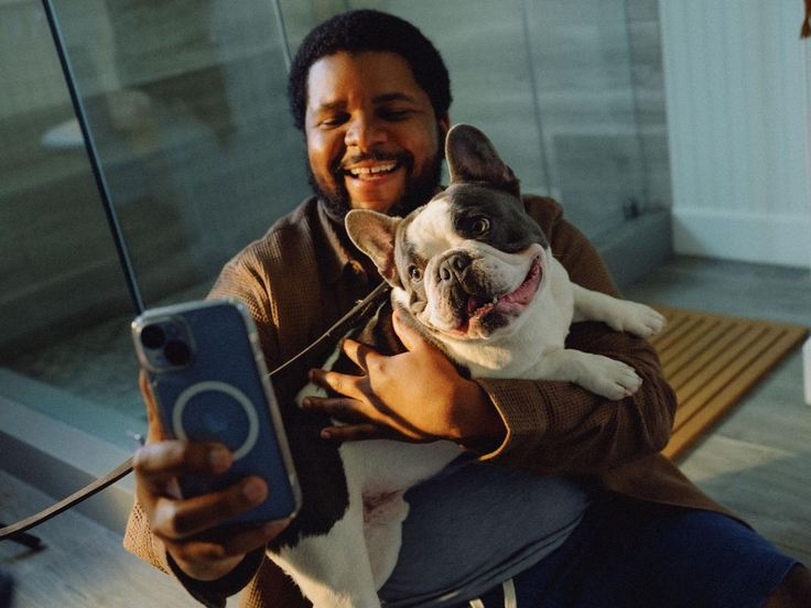 A happy pet parent taking a selfie with their French bulldog