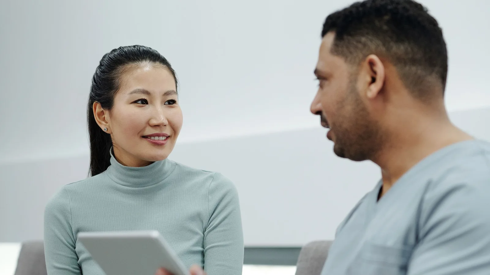 A healthcare professional speaking with a patient during a private consultation
