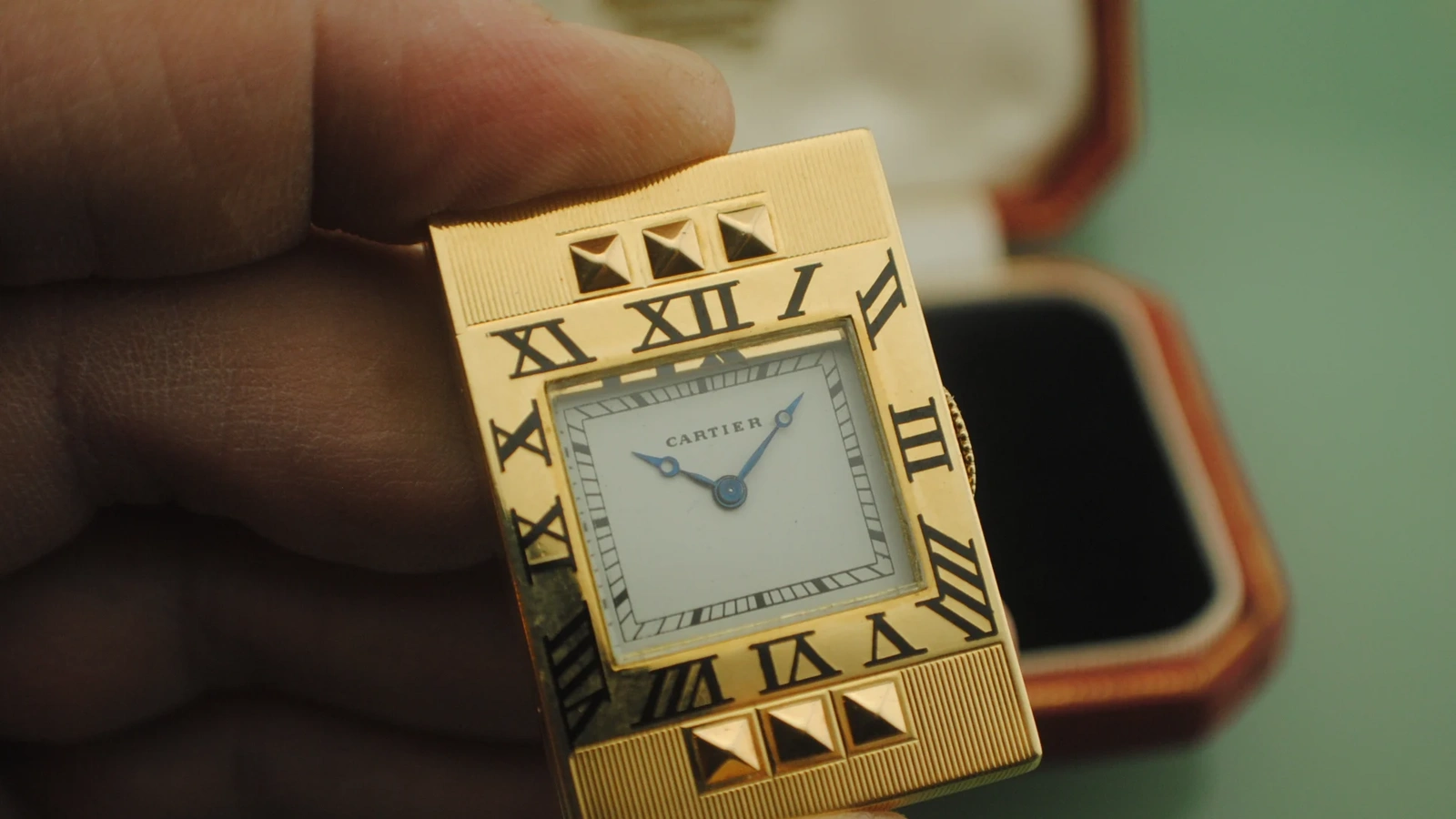 Wider clean view of the Cartier Guillotine opened to reveal its signed white dial, blued hands, and decorated gold front