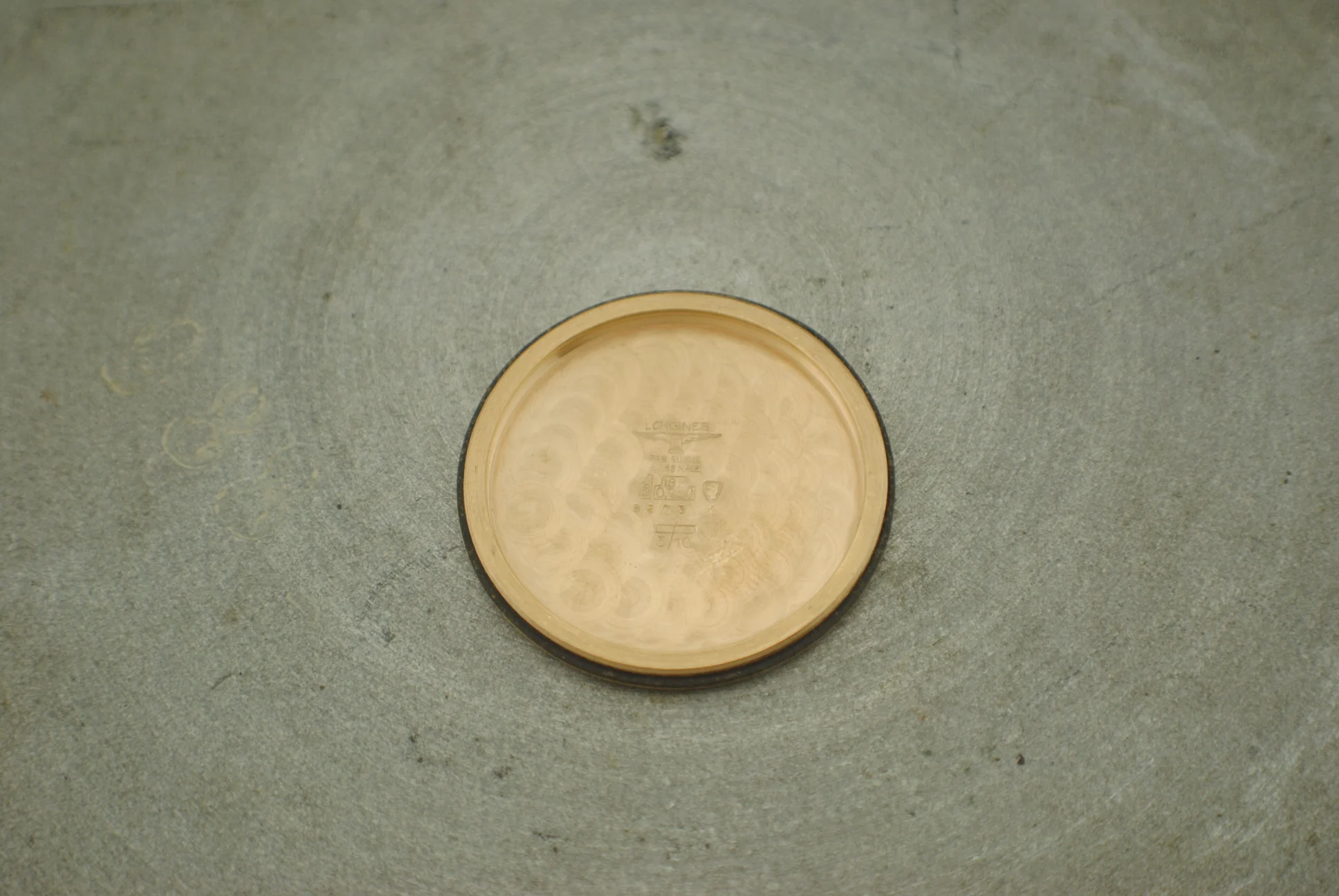 Inside of the removed rose-gold Longines Nonius caseback with hallmarks